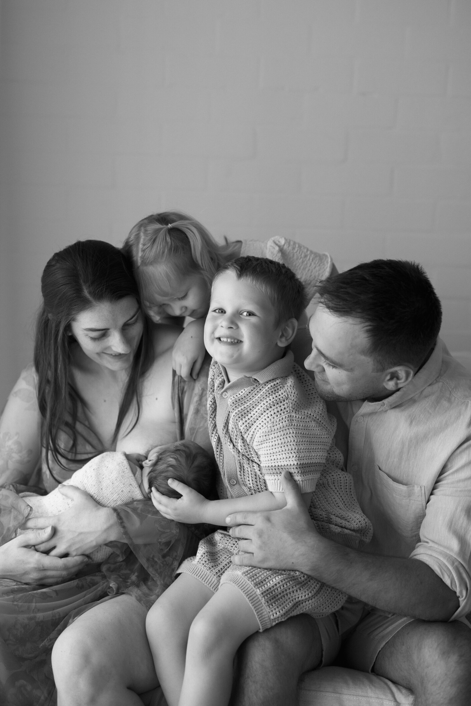 Gentle and intimate newborn family photoshoot in Perth, featuring warm studio lighting and timeless family moments.
