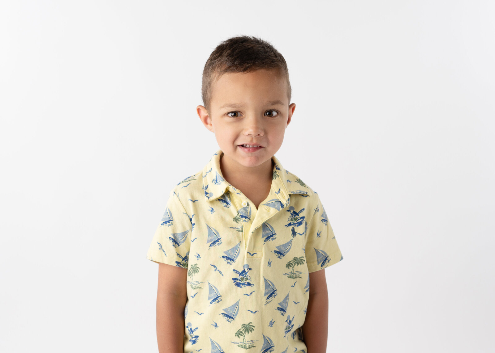 A shy young boy smiling softly in his school portrait.