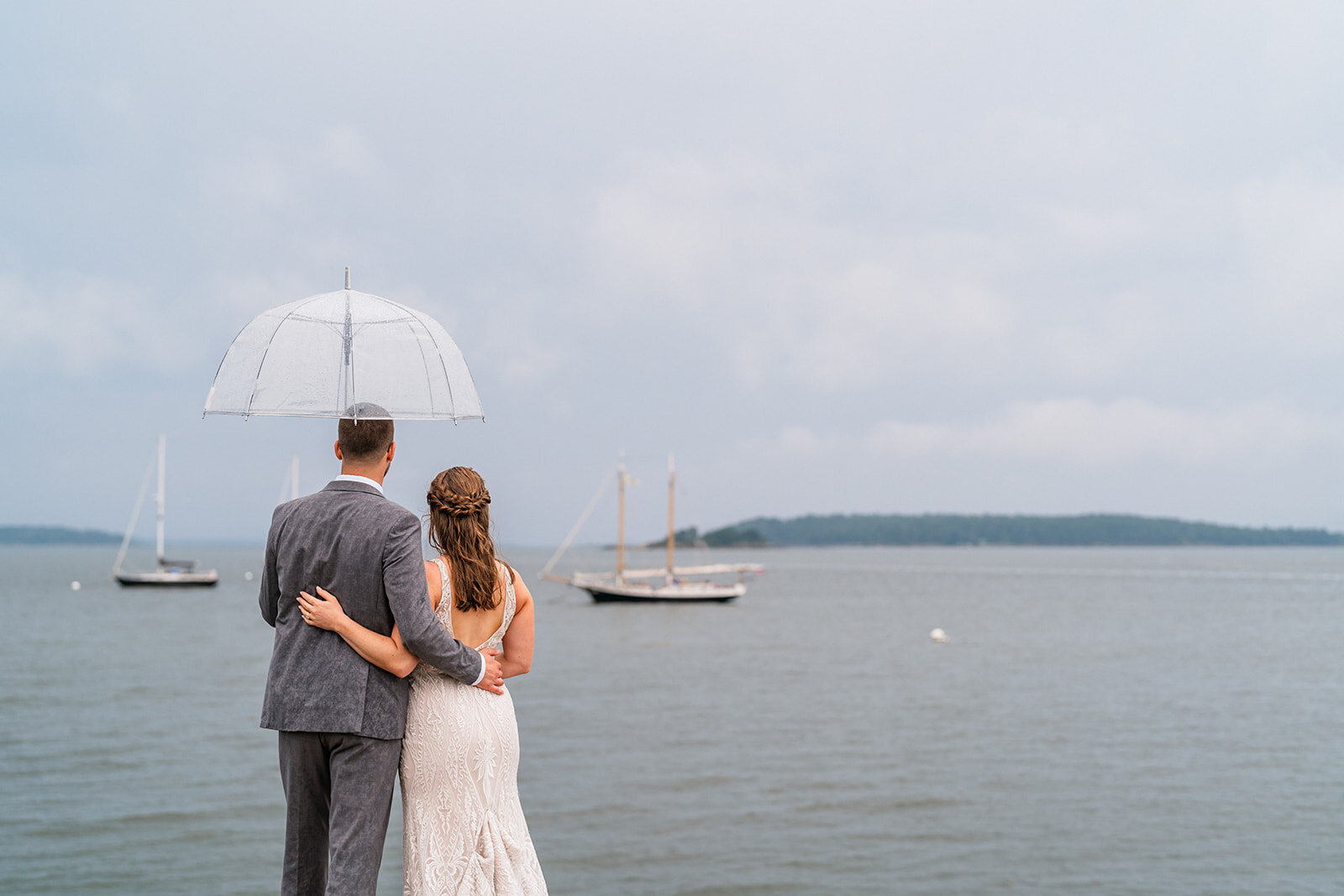 A couple standing on a jetty in Freeport, Maine during their Maine elopement day.