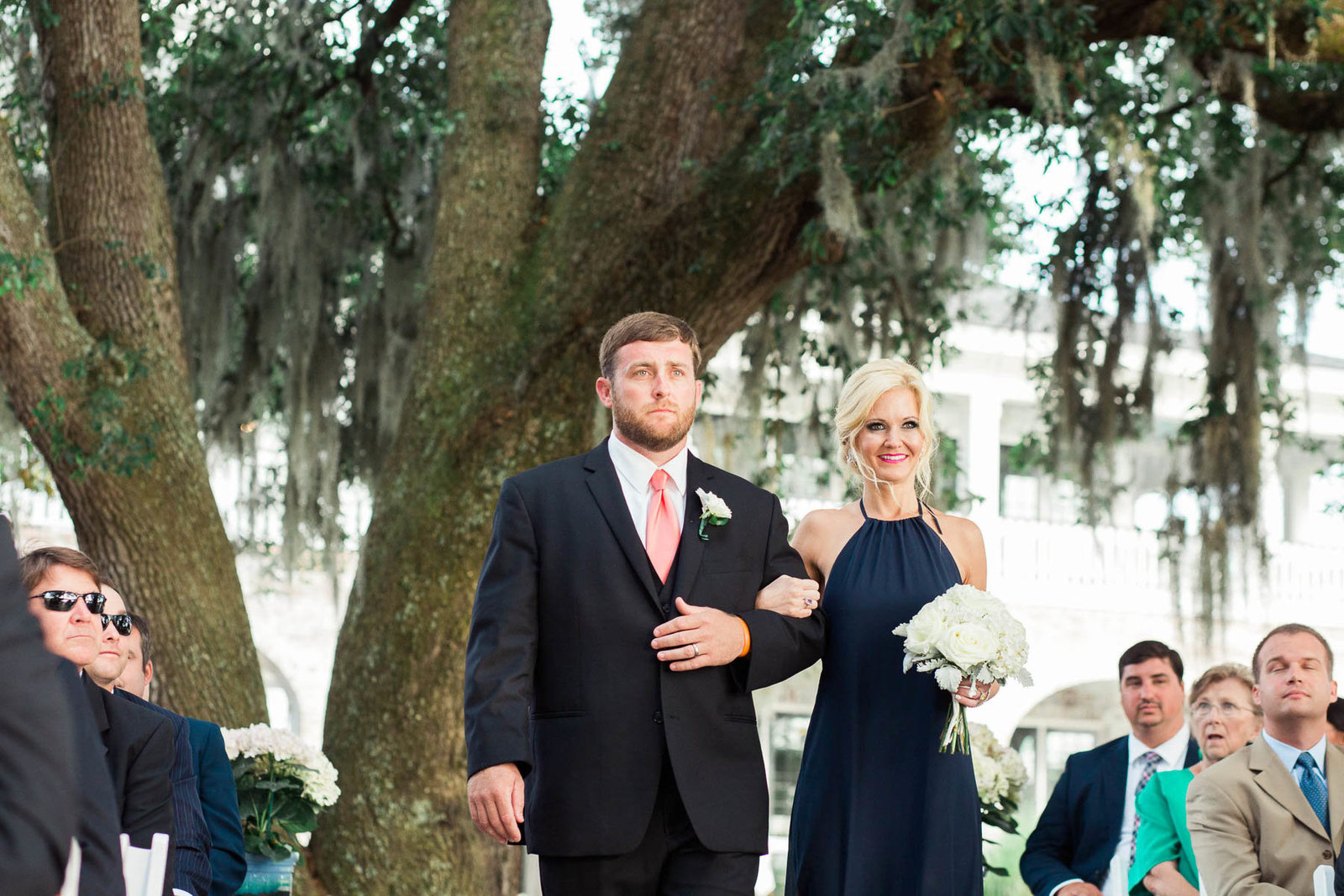 Bridesmaid and groomsman walk down the aisle, Dunes West Golf and River Club, Mt Pleasant, South Carolina