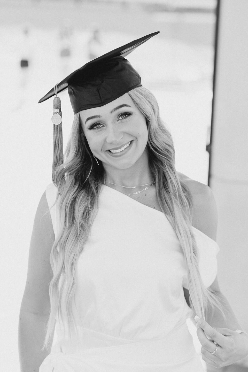 Girl in graduation cap smiles at UGA stadium