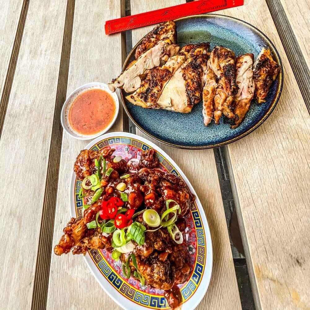 Two dishes containing Vietnamese food, with bright chillies and dipping sauce