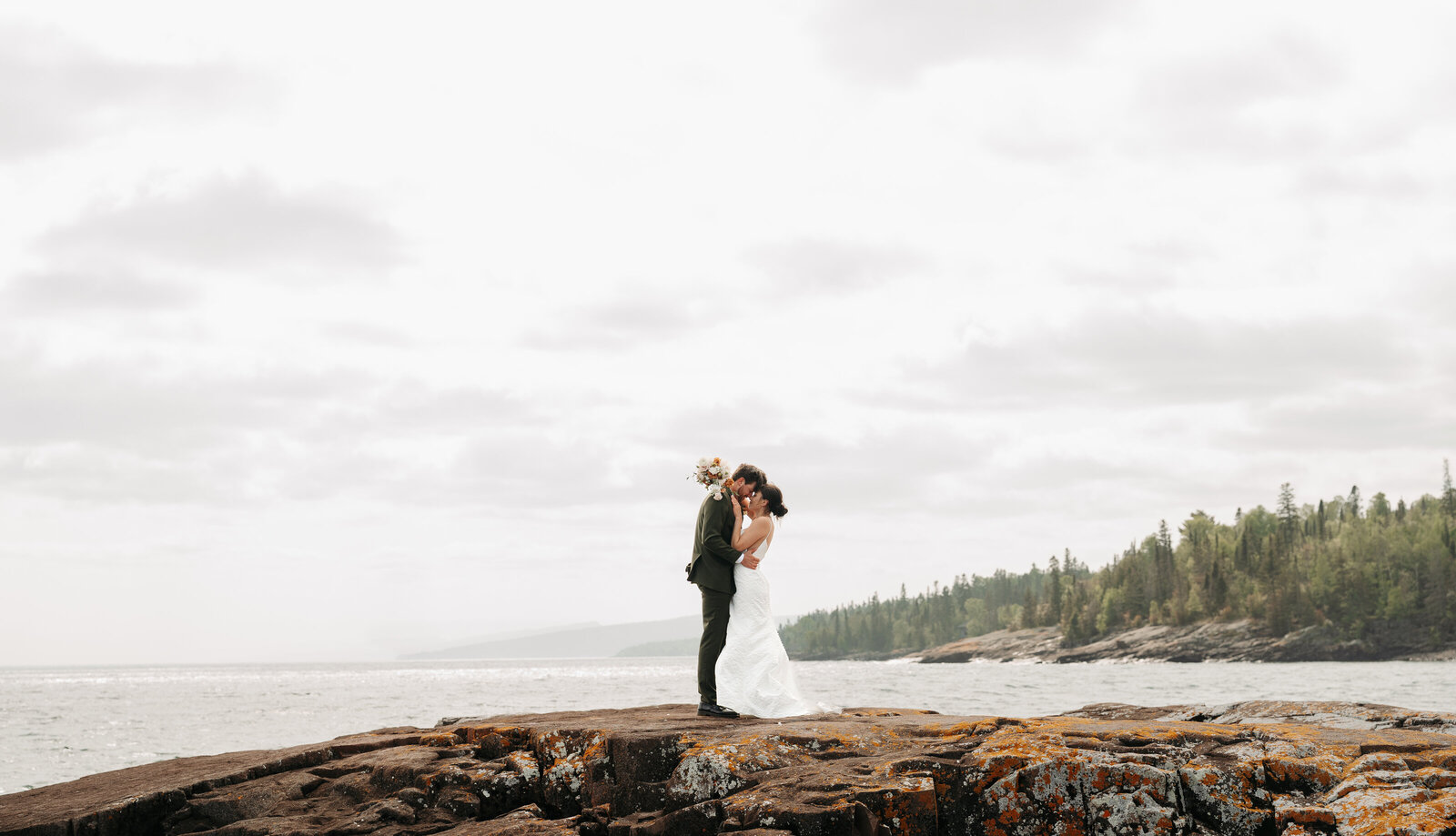 bride and groom snuggling up on the north shore of Duluth Minnesota, take by Minnesota wedding photographer,  Kelly Friday Photography.