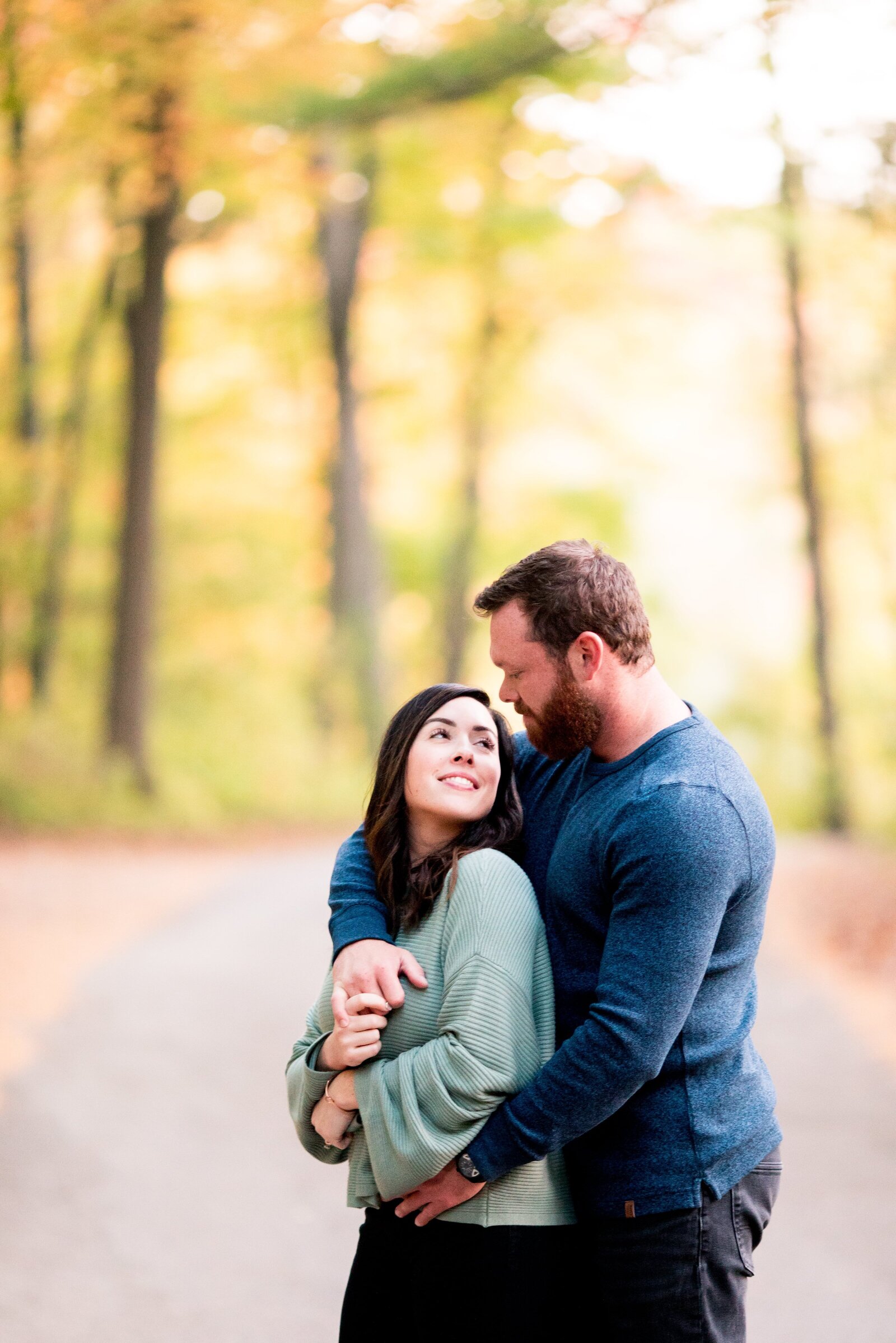 Couple embracing during fall engagement session.