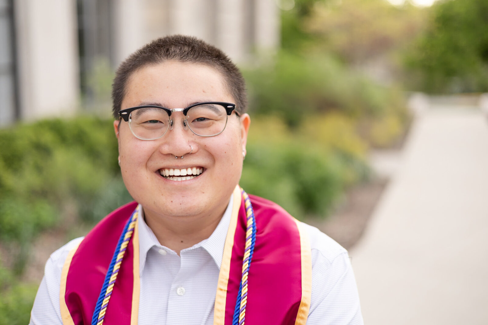 young man poses for college graduation photo at the Memorial Union