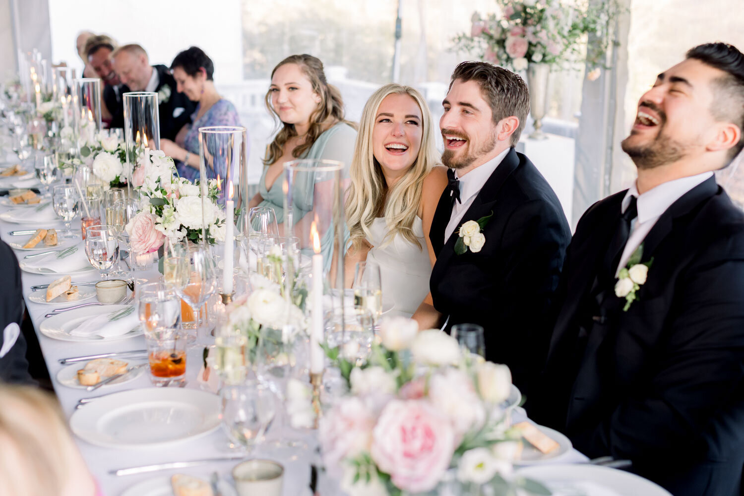 Guests laughing and enjoying a beautifully set wedding dinner table