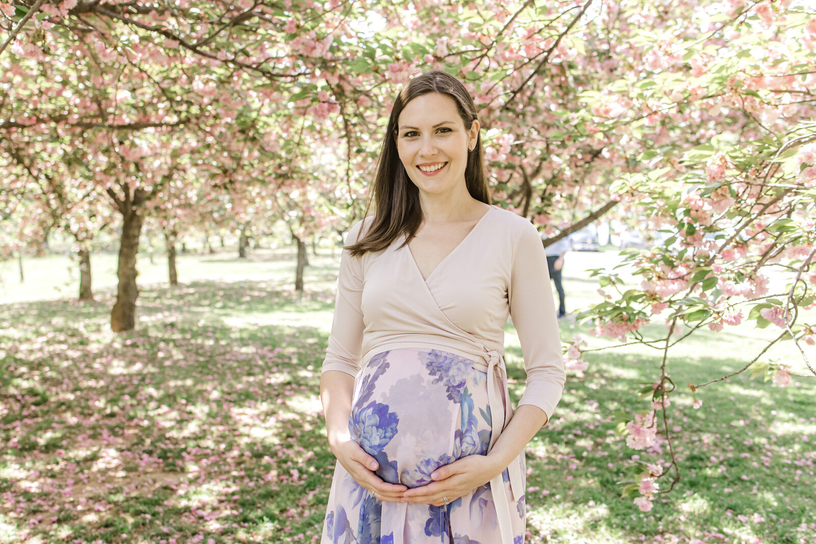 Pregnant woman under cherry blossom tree