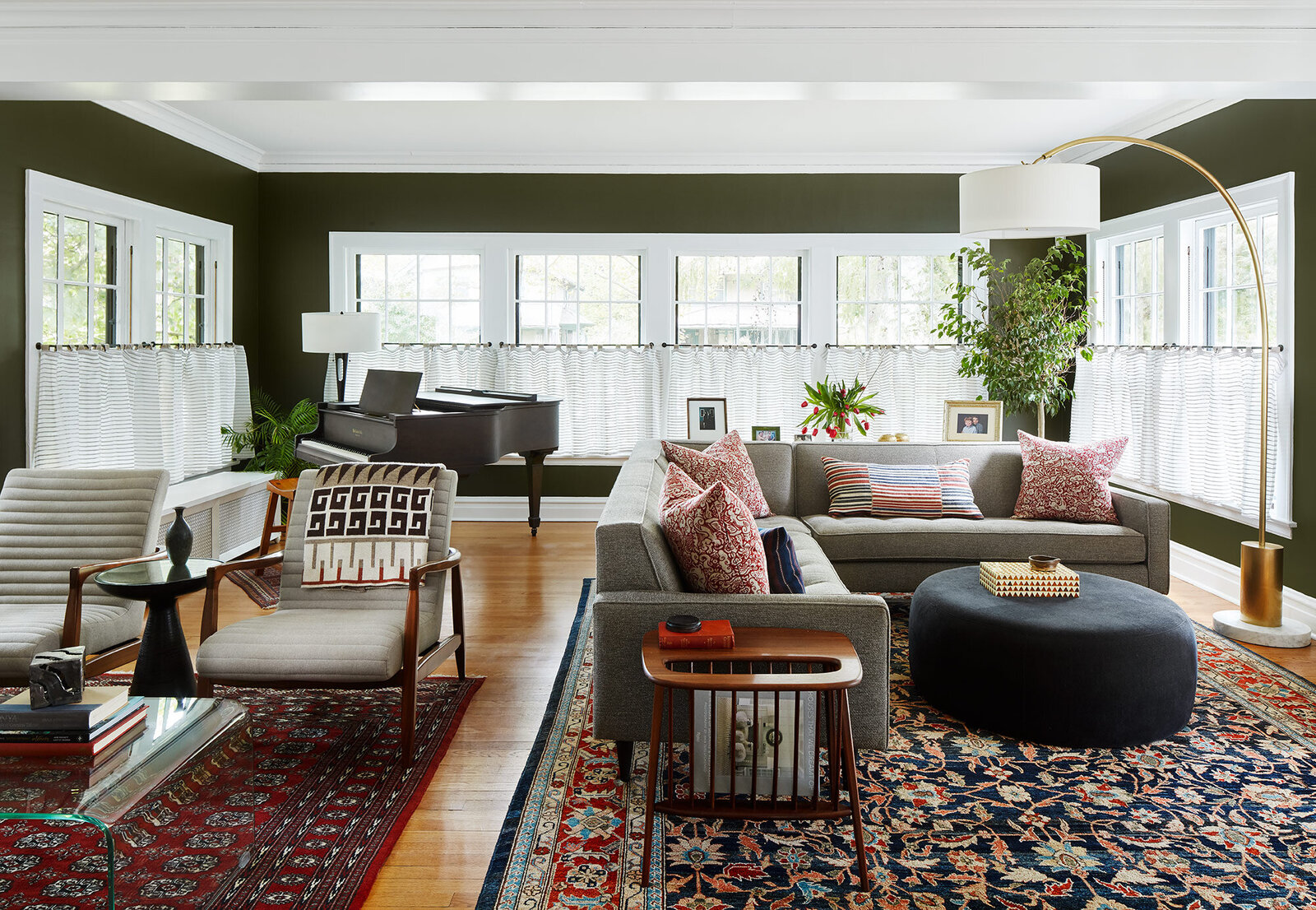Midcentury living room design with olive green and grey decor and colorful patterned rugs