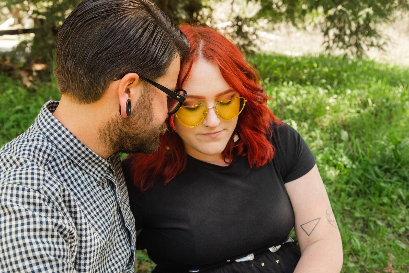 An tattooed engaged couple poses for photos in a redwood forest in Santa Cruz, Ca.