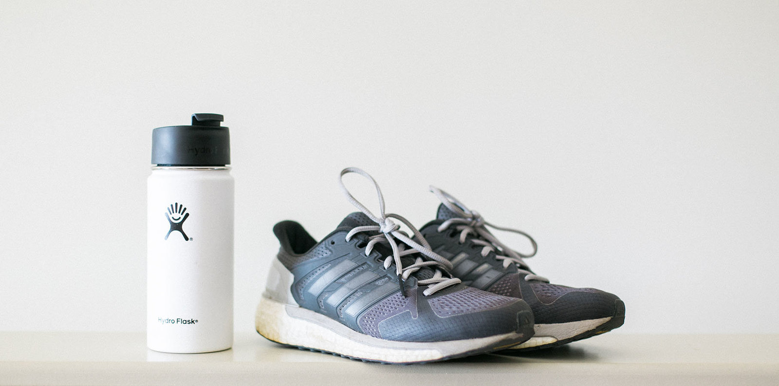 gray running shoes and white water bottle,  photo by My Brand Photographer