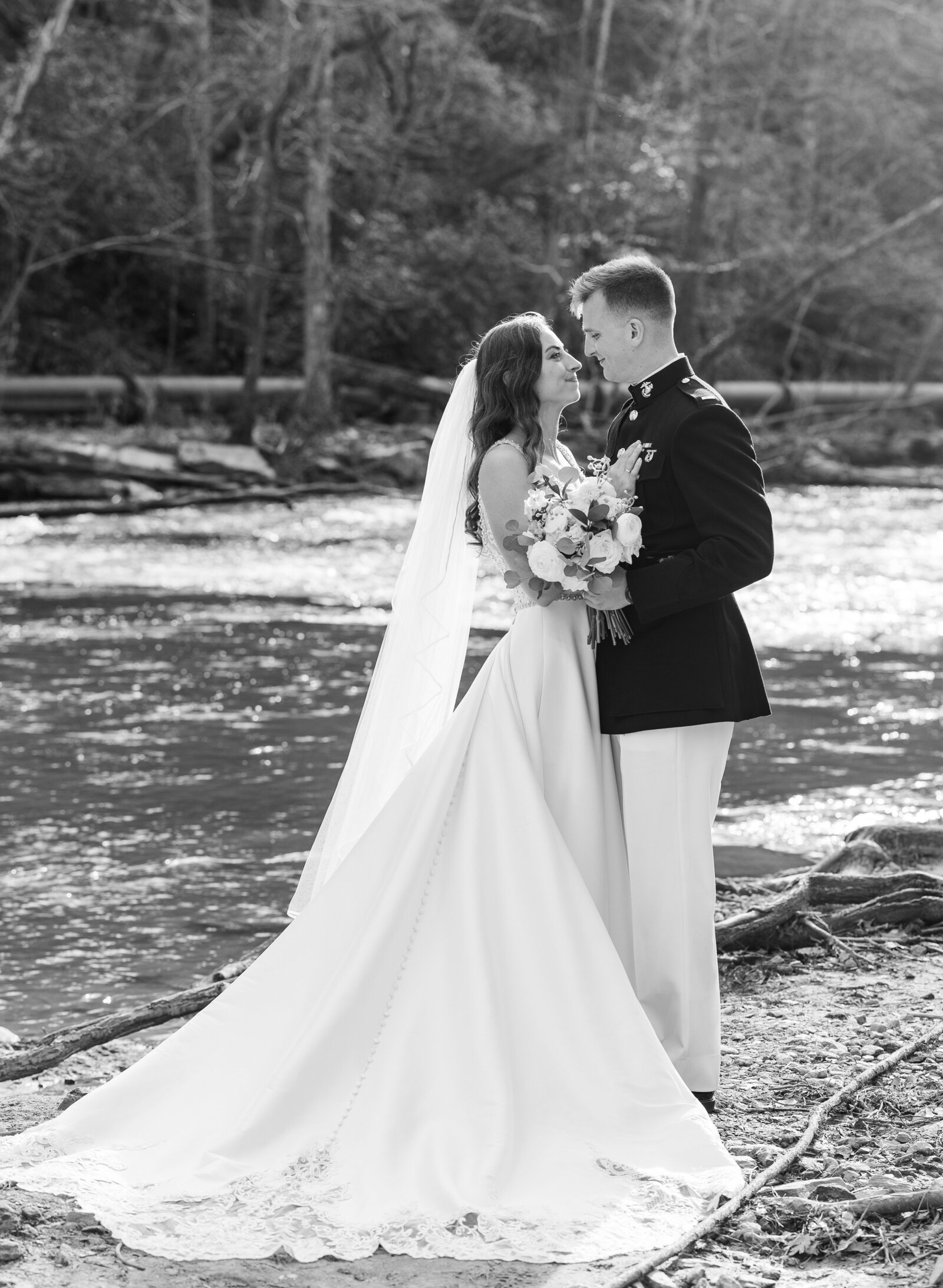 bride and groom embracing by a pond