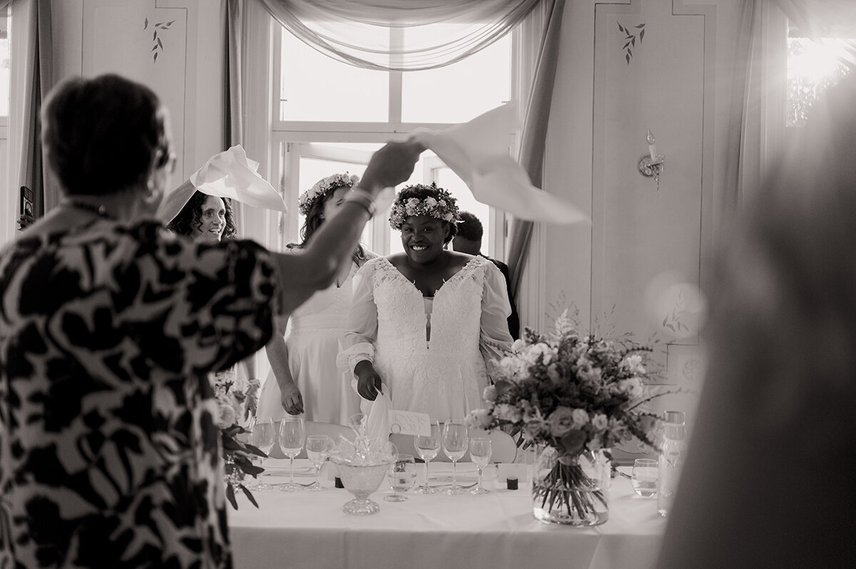 Bruden blickar mot kameran och gästerna snurrar sina servetter