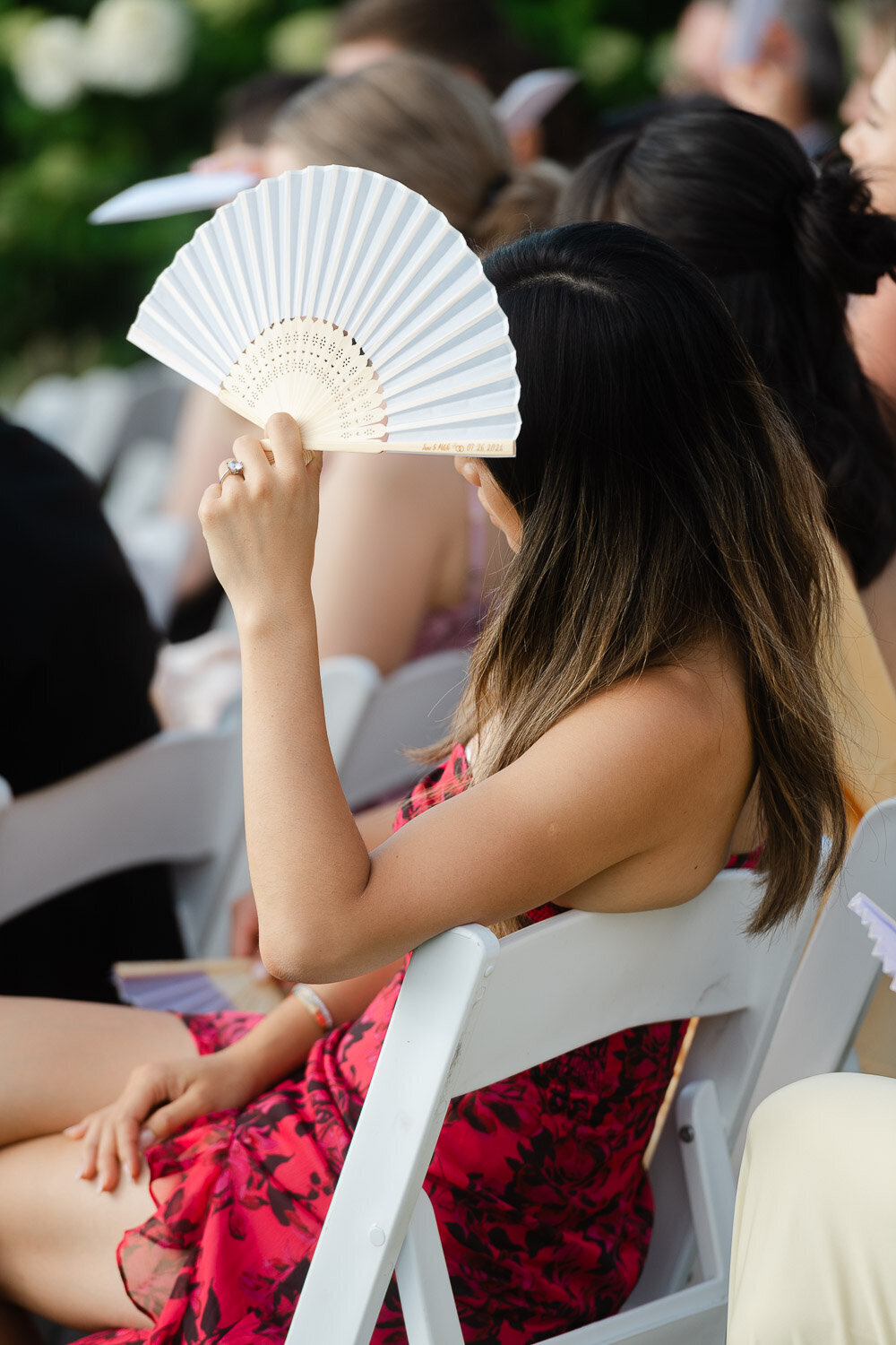 guest sitting at ceremony with fan
