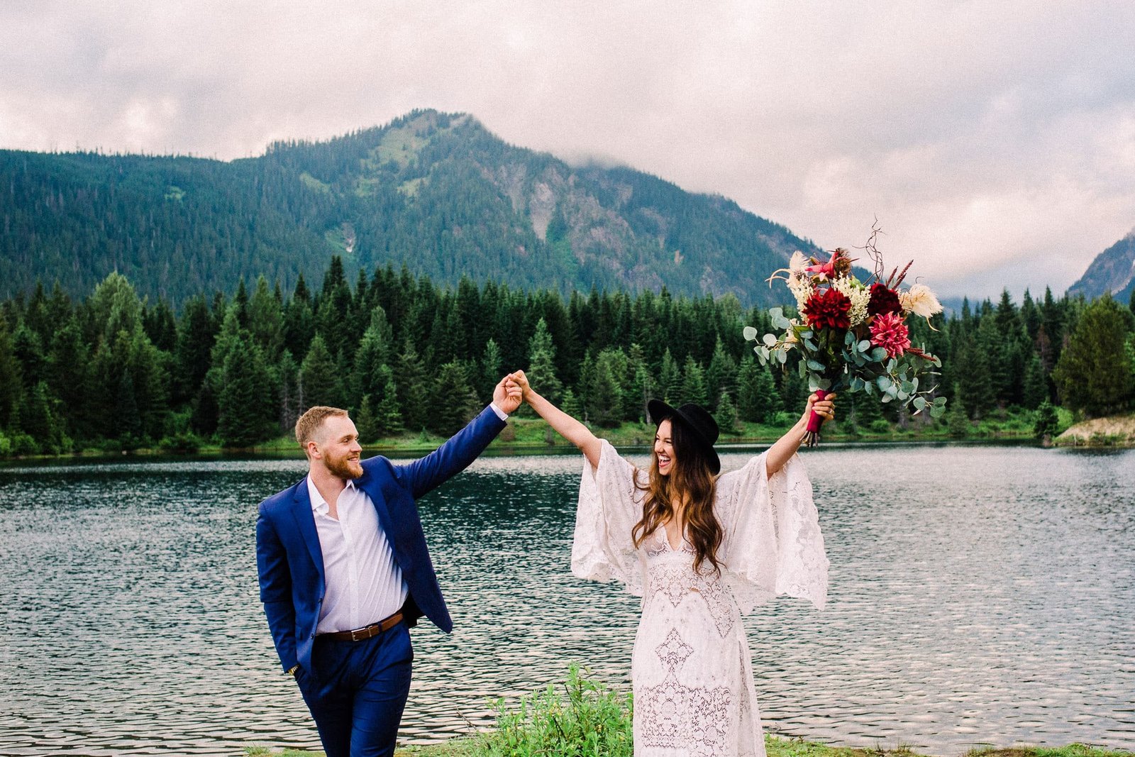 Bride and groom excitedly throwing hands in the air at PNW mountainside