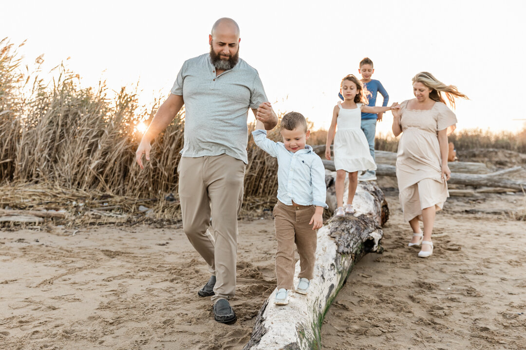 Little boy and siblings walking on driftwood on NJ beach