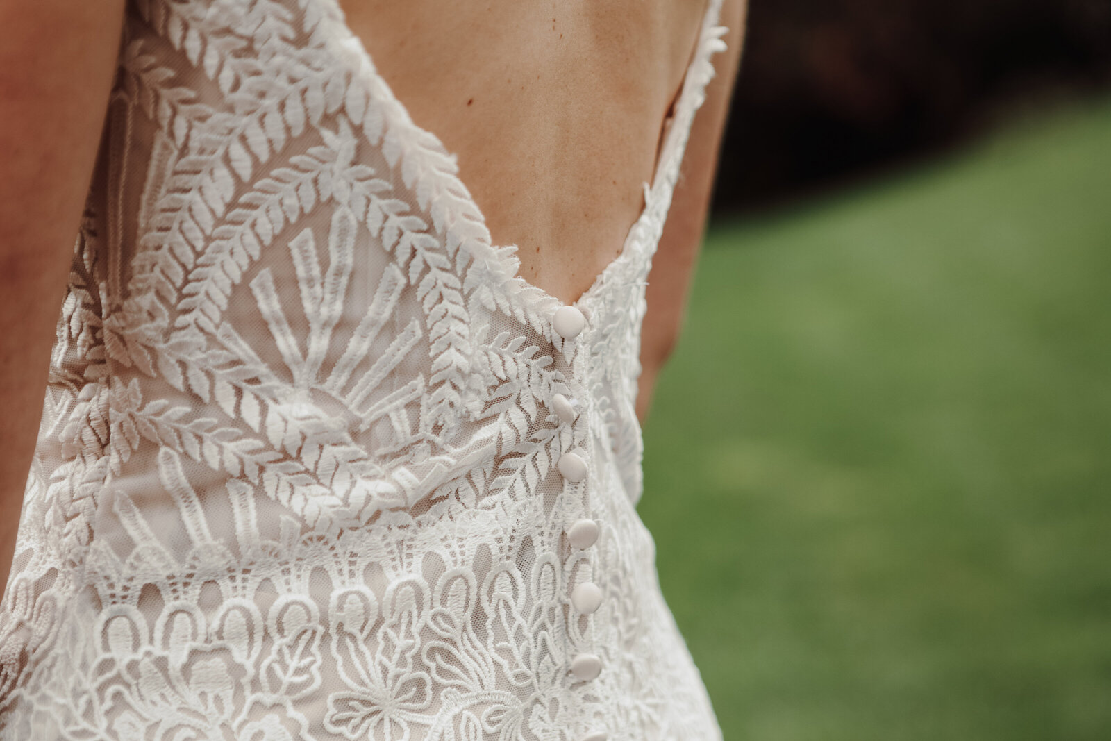 The back of a bride's vintage wedding dress with lace and buttons