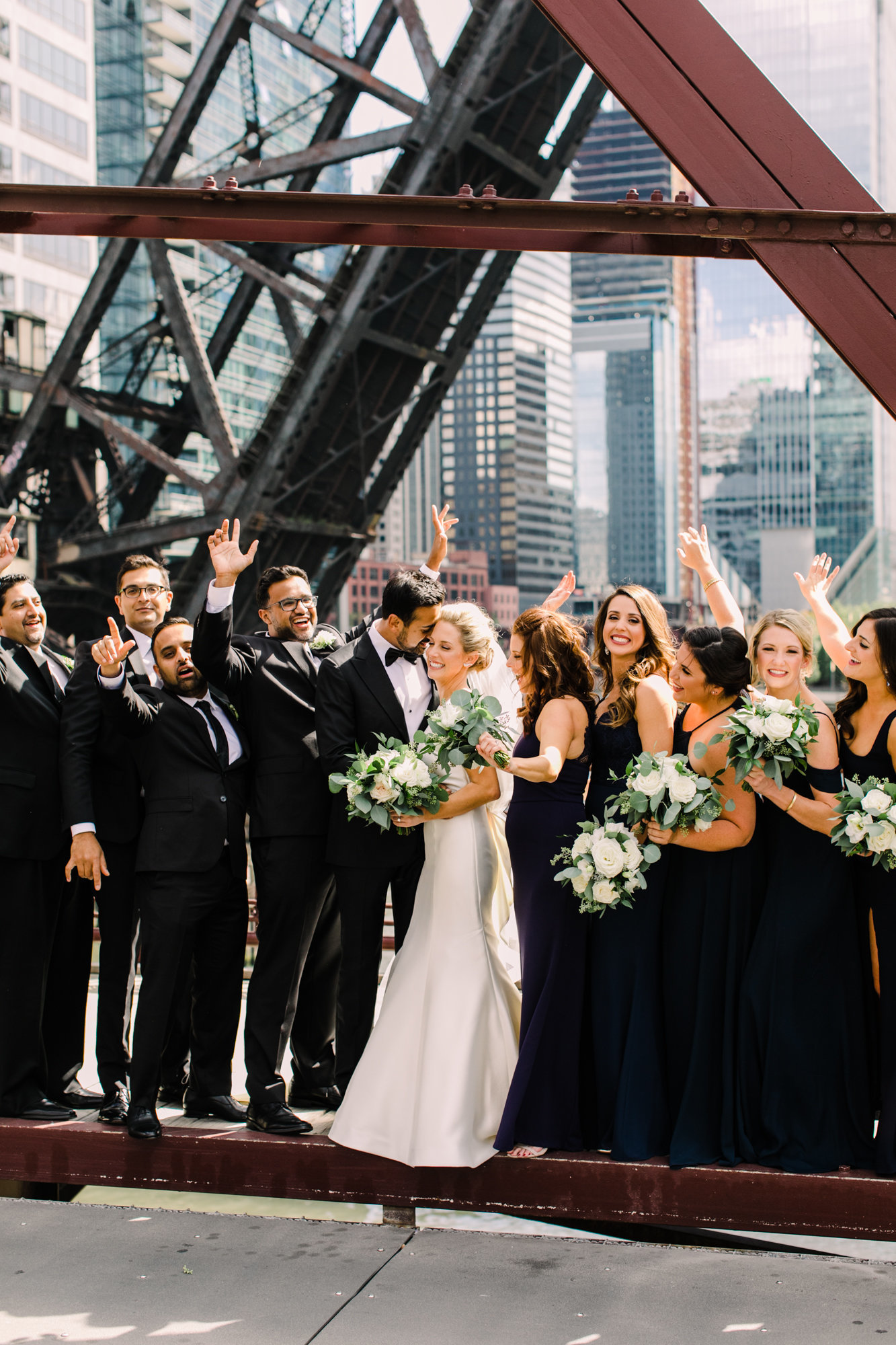 Wedding party poses for a portrait standing on the Kinzie Street Bridge in Chicago, IL.
