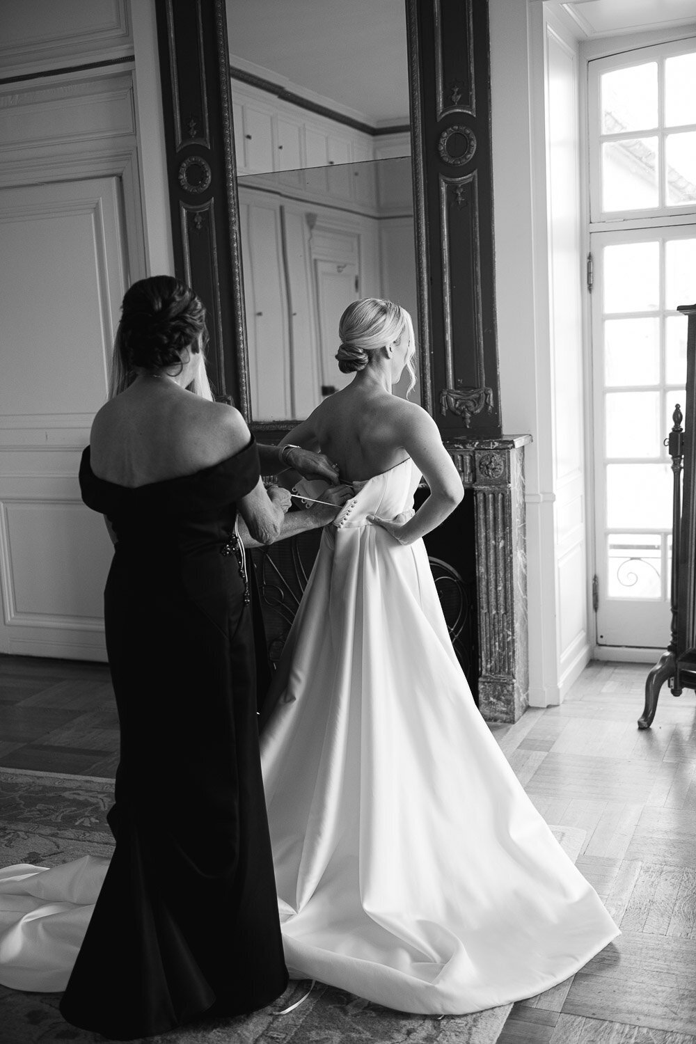 bride getting dress buttoned from behind