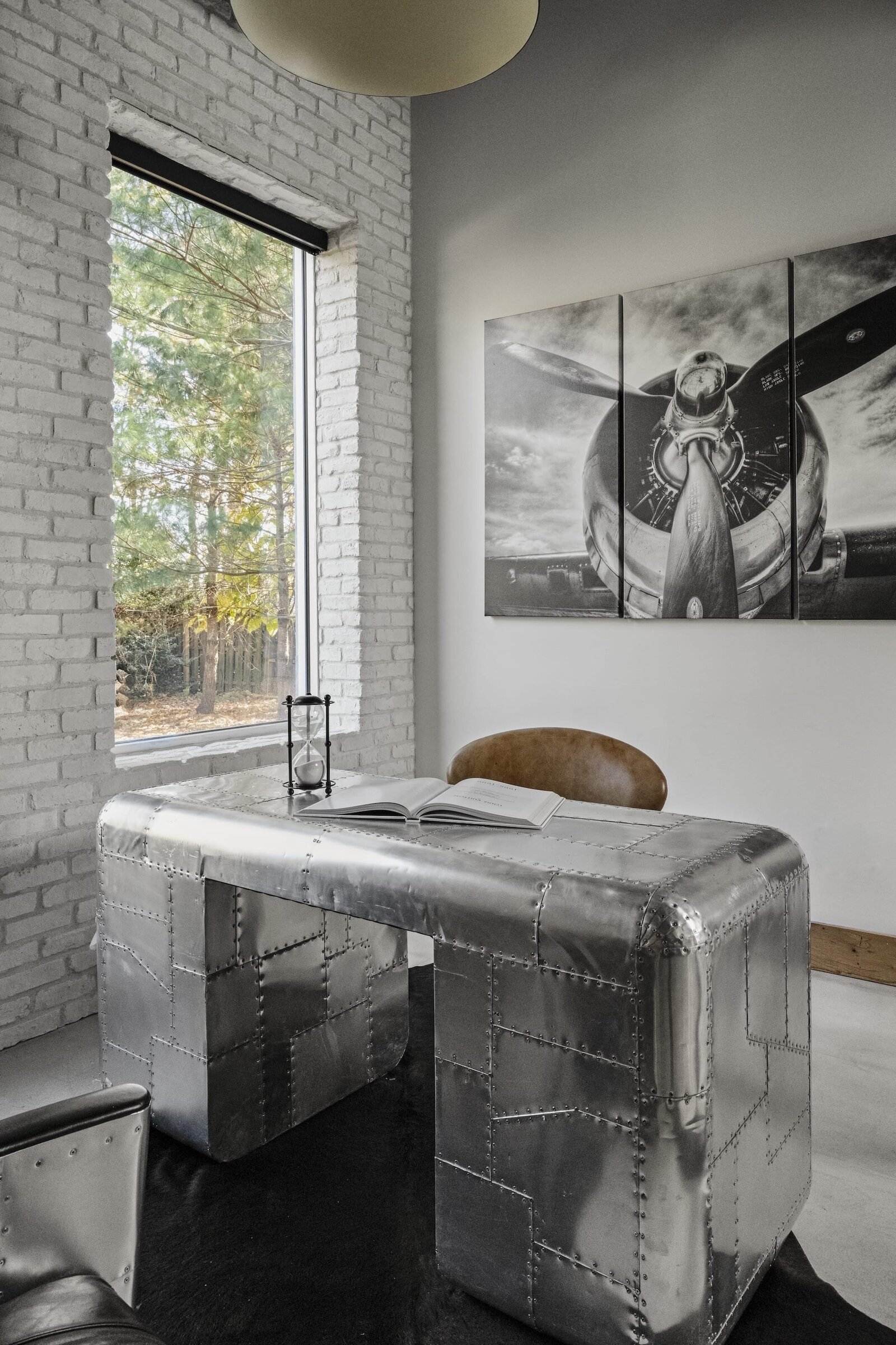 candra lynn interiors old bridge project metal office desk with leather chair and large black and white artpiece on wall
