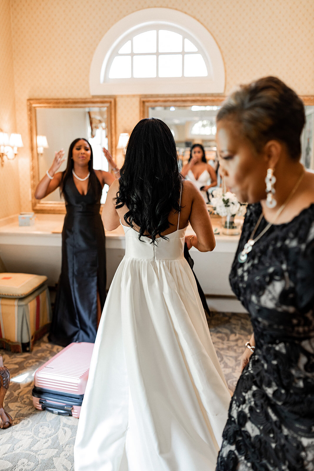 Bride in a taffeta wedding dress getting ready with her bridesmaids and the mother of the bride