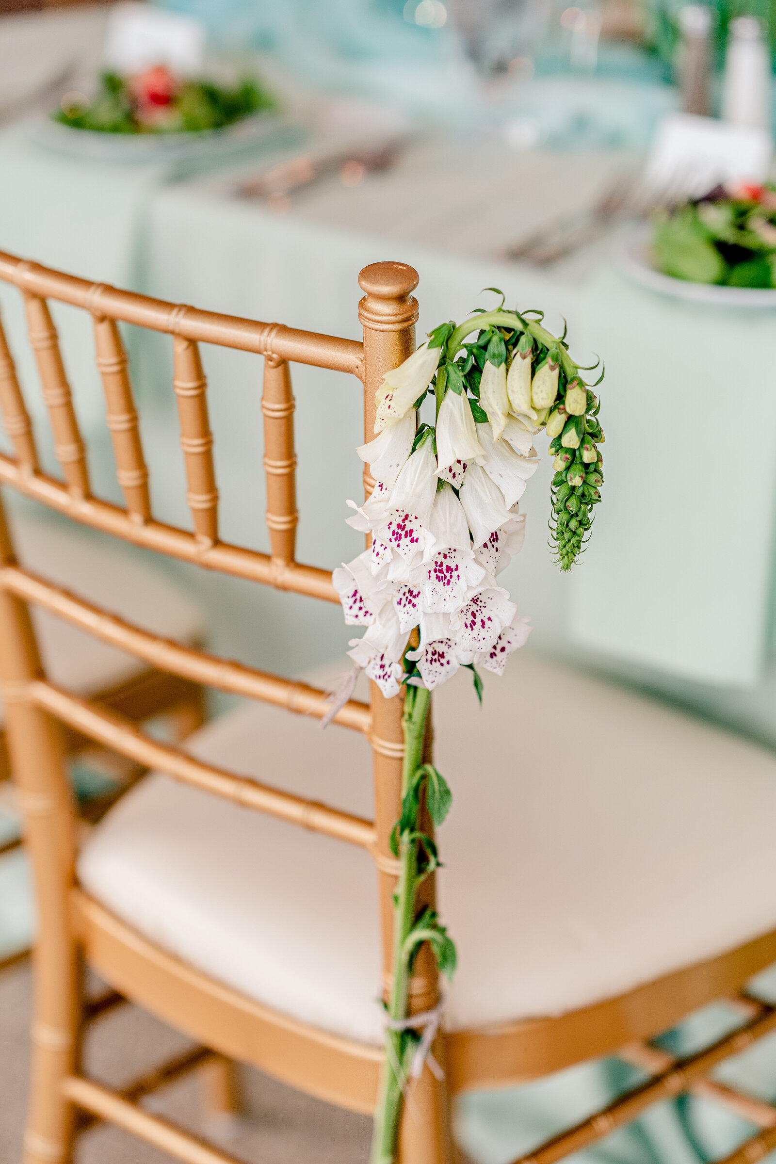 A beautiful flower tied to a chair at the sweetheart table during a wedding at Rust Manor House in Leesburg Virginia