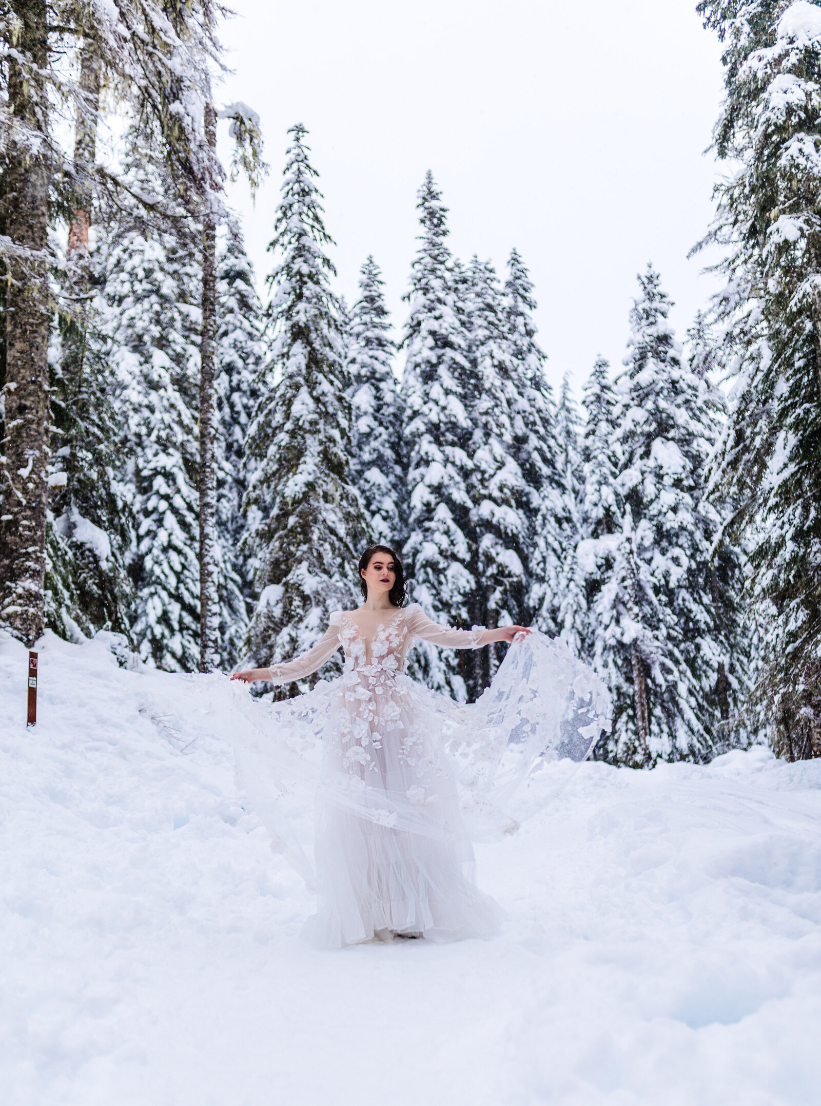 Bride and groom walking through snow-covered trees, perfect for styled shoots for adventurous photographers in the Pacific Northwest.