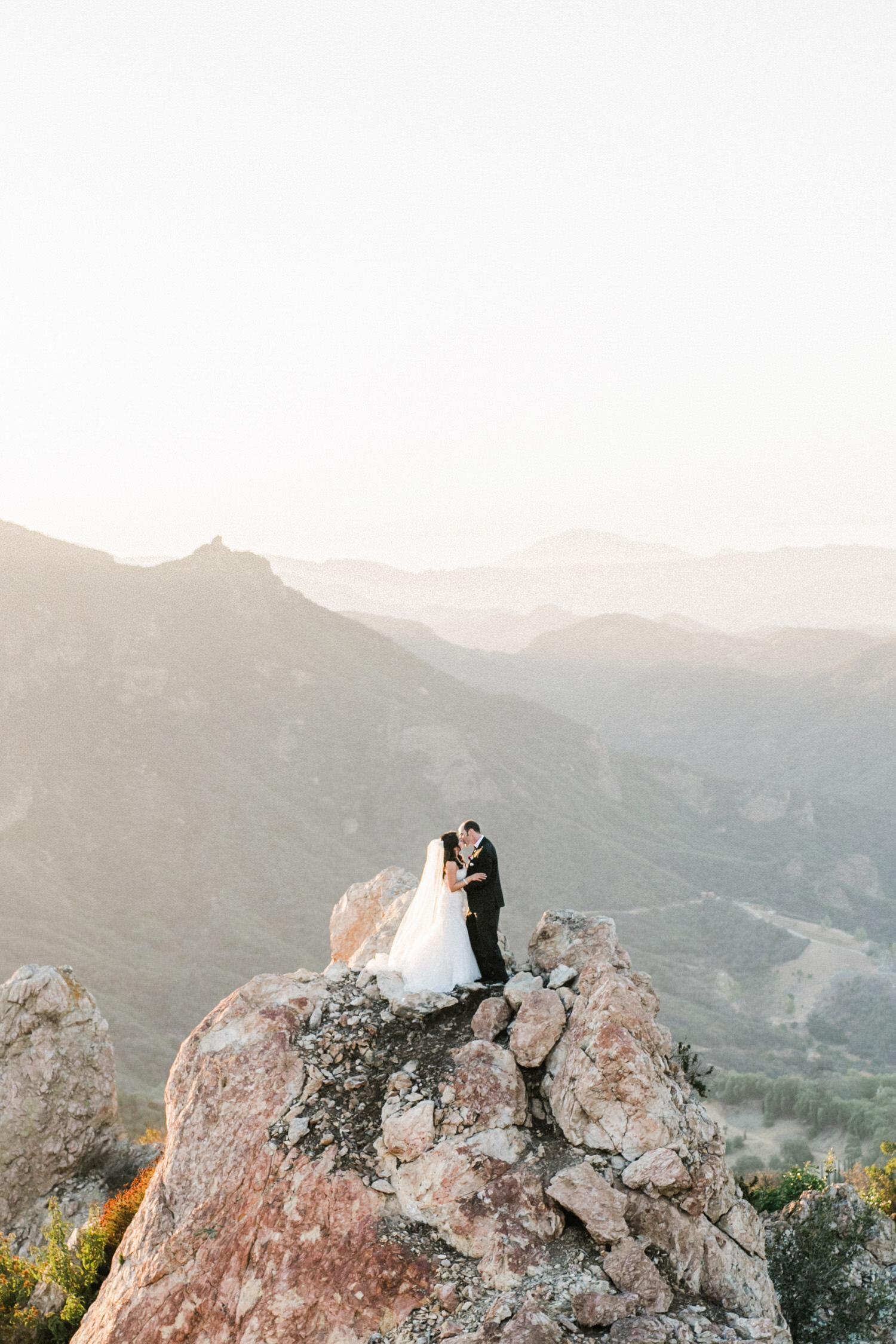 Bride and groom embrace on the top of a mountain at Malibu Rocky Oaks