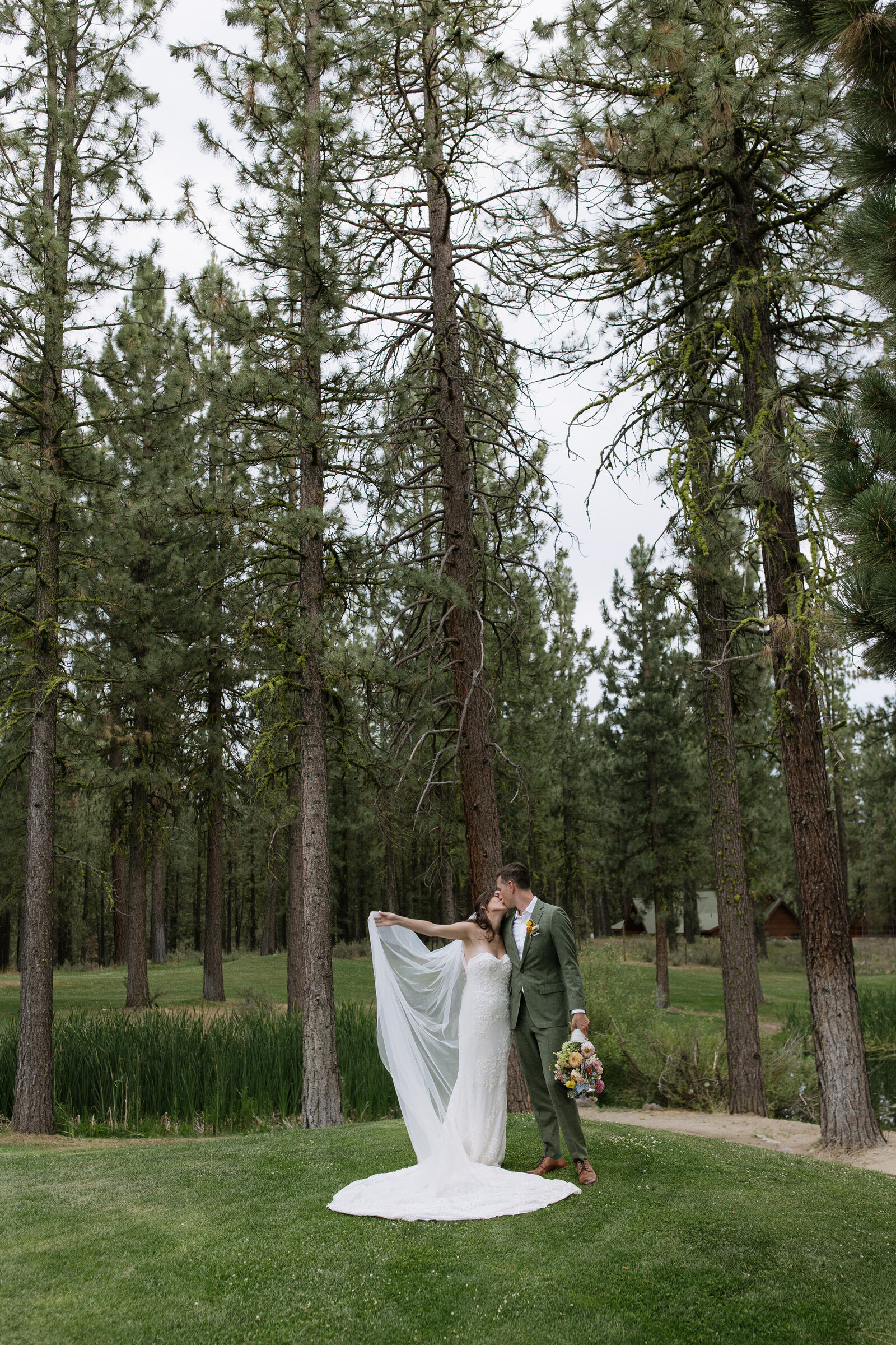 Bride and groom posing in forest and colorful florals in Tahoe