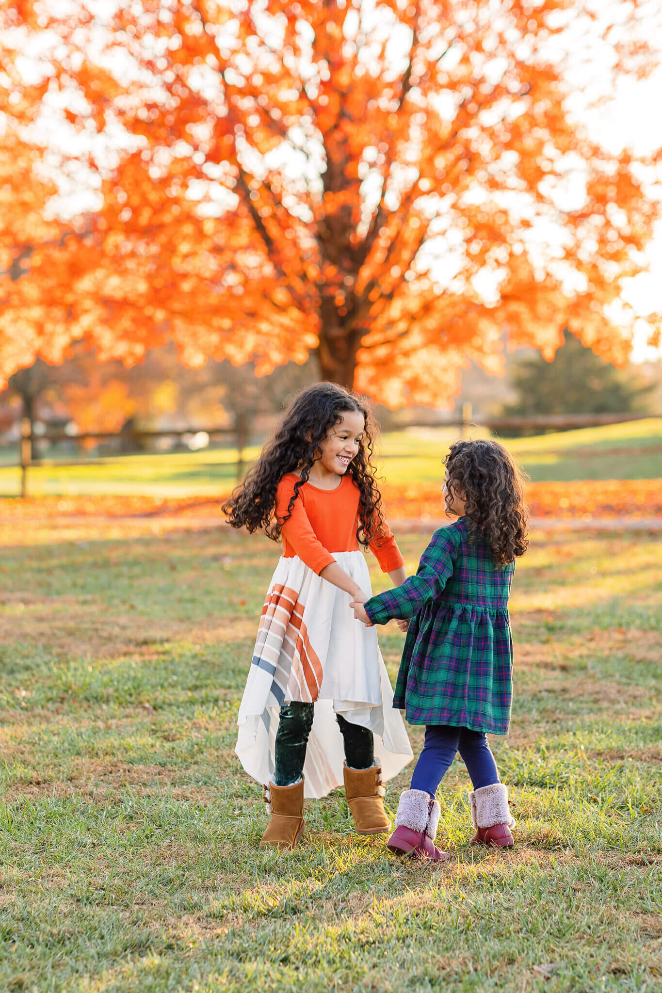 Two sisters dancing together at Burke Lake Park in the fall