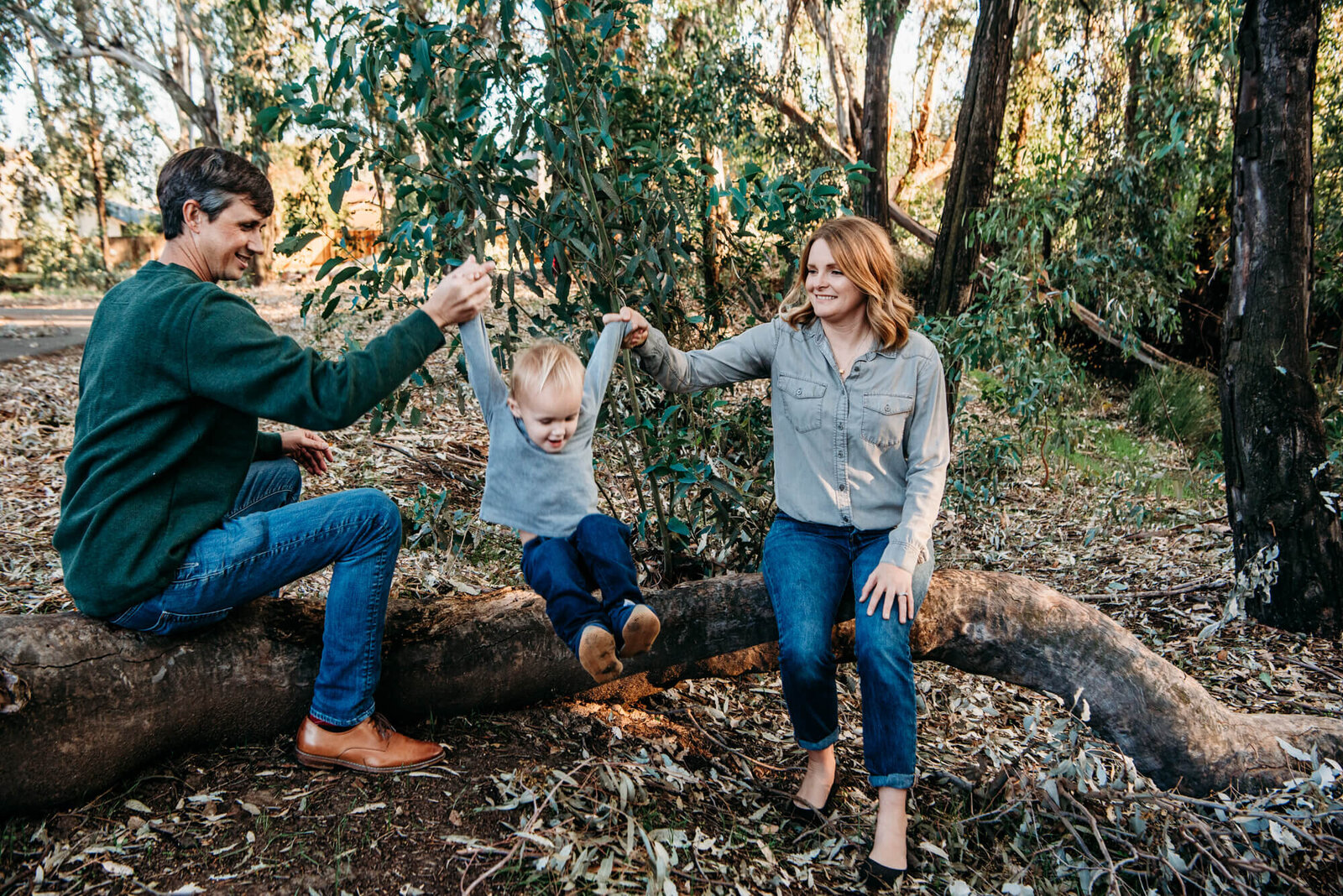 boy jumps with help from mom and dad during family photo shoot