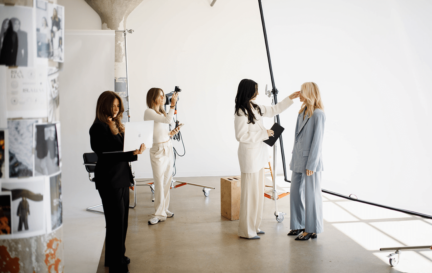 Picture of girls working at a photoshoot with a laptop, iPhone and camera