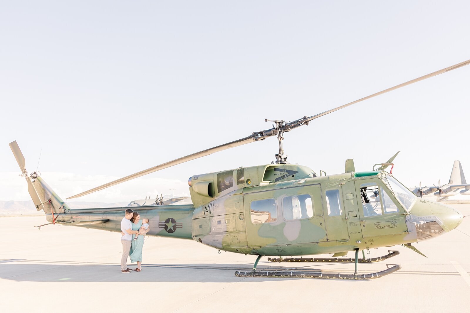 Wide family shot in front of a Huey