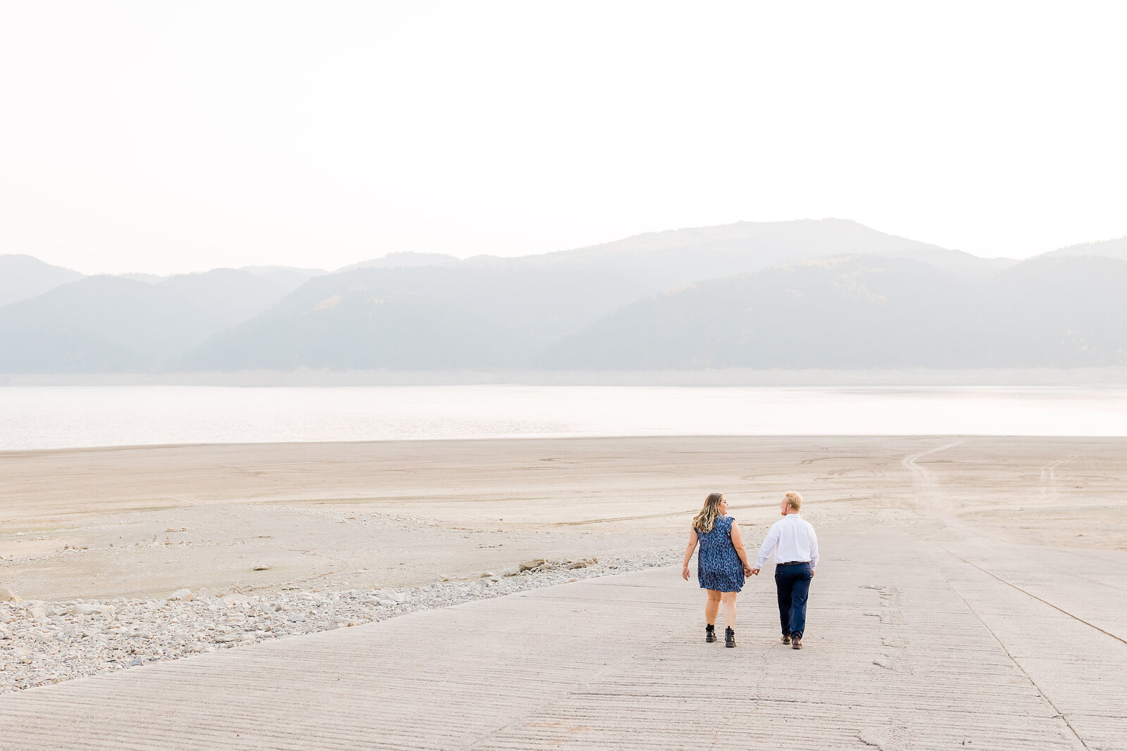 Couple walking on the beach of a beautiful lake taken by Utah Wedding Photographer in the fall.