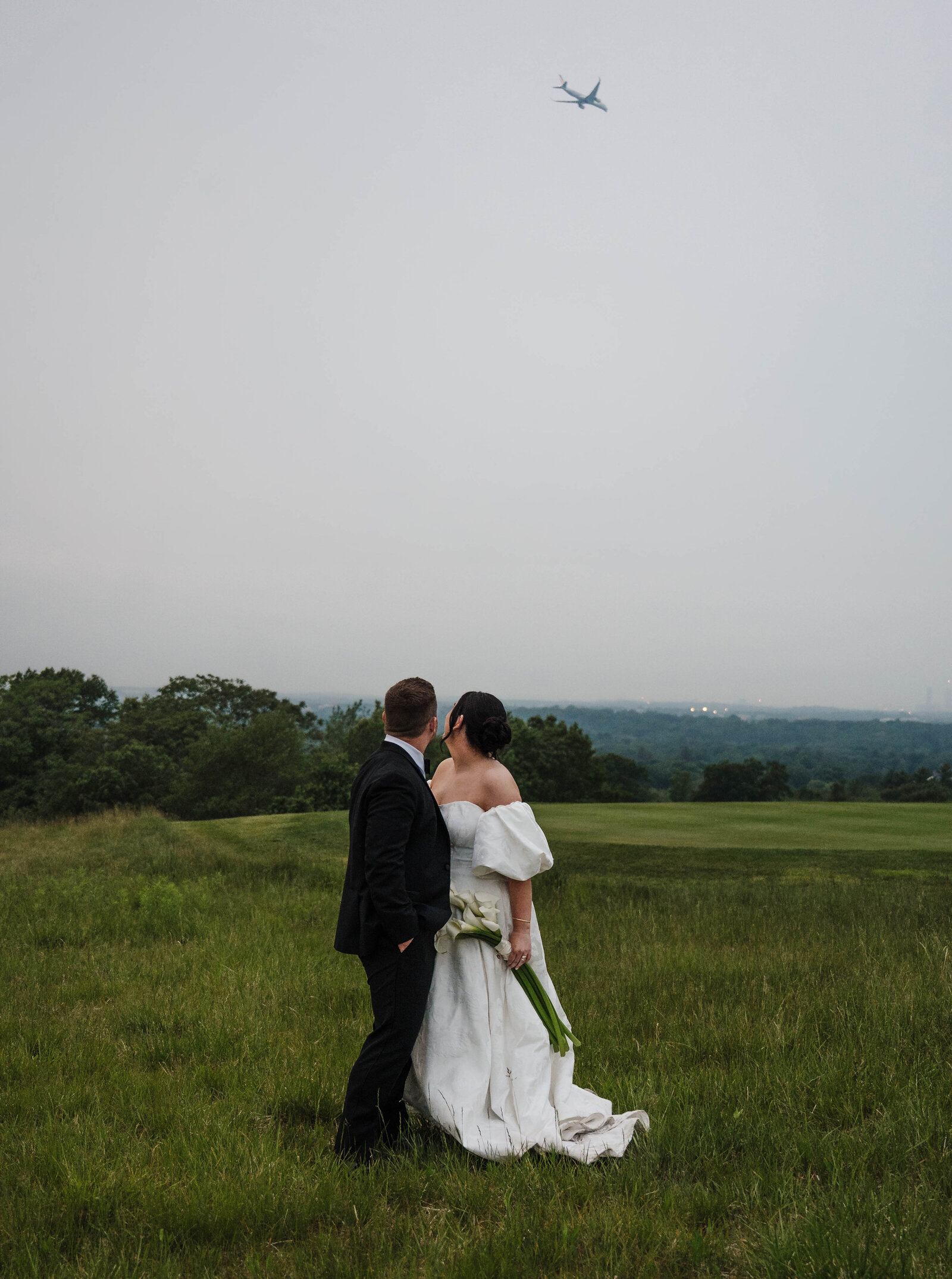 Bride and Groom embracing looking at the Boston Skyline during their Massachusetts wedding 