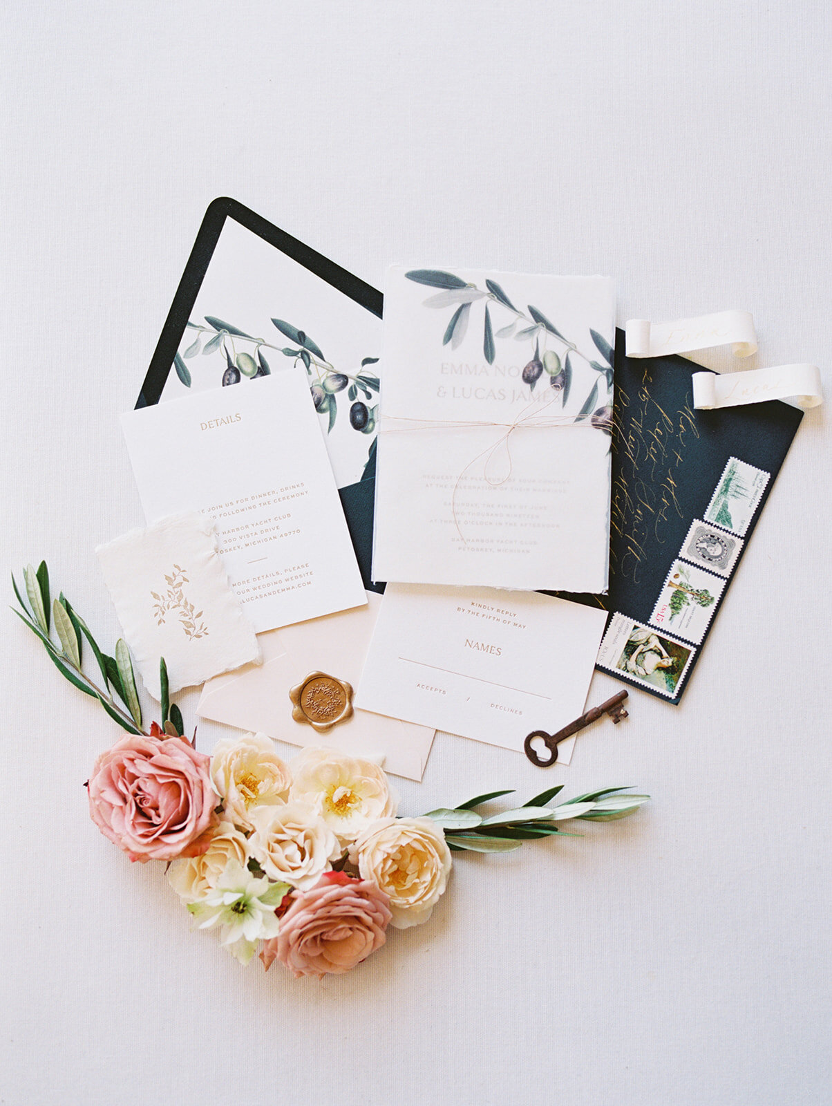 A detailed photo of wedding invitations with flowers next to them