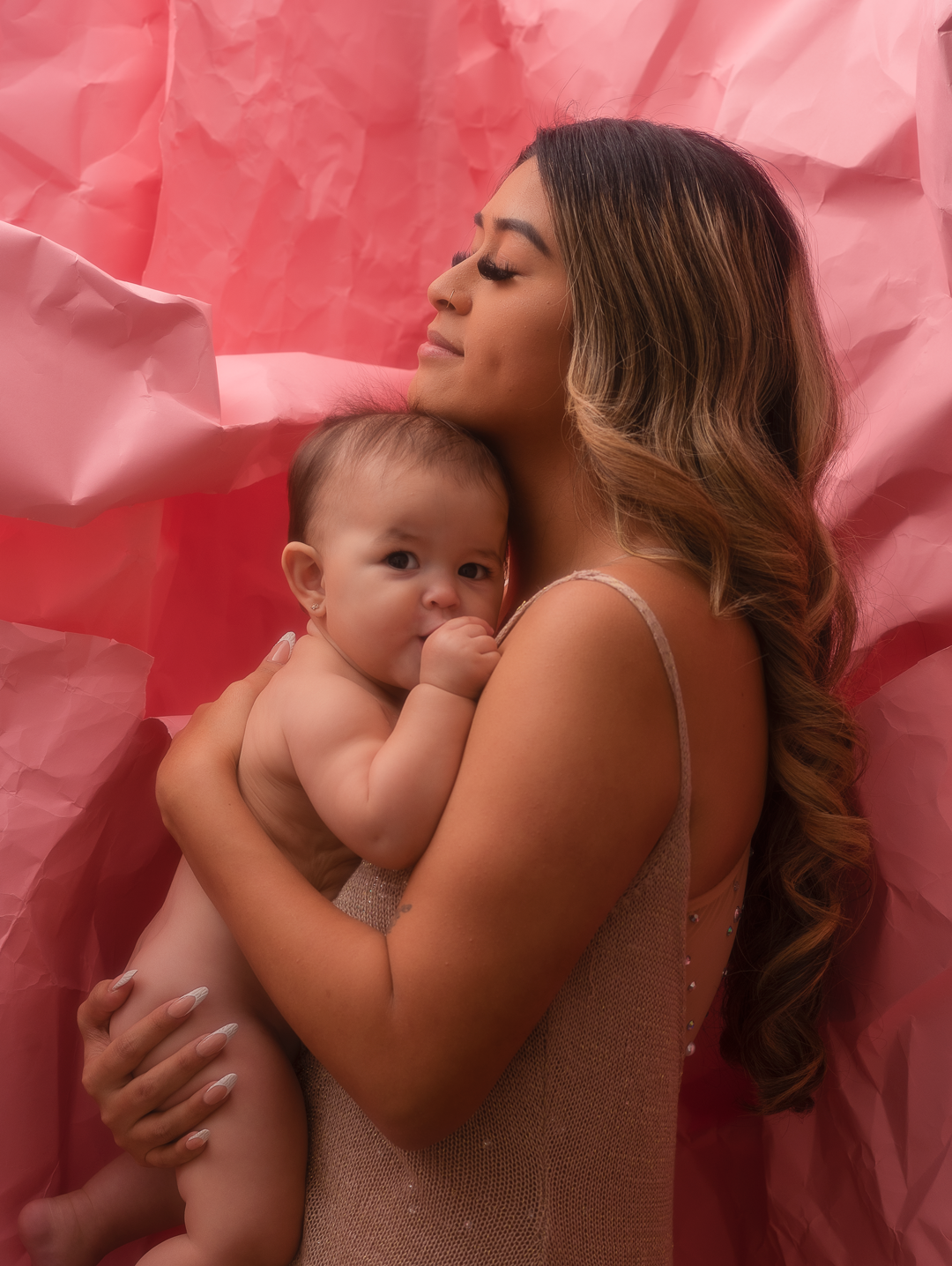 Mom embracing 9 month old daughter in crazy backdrop