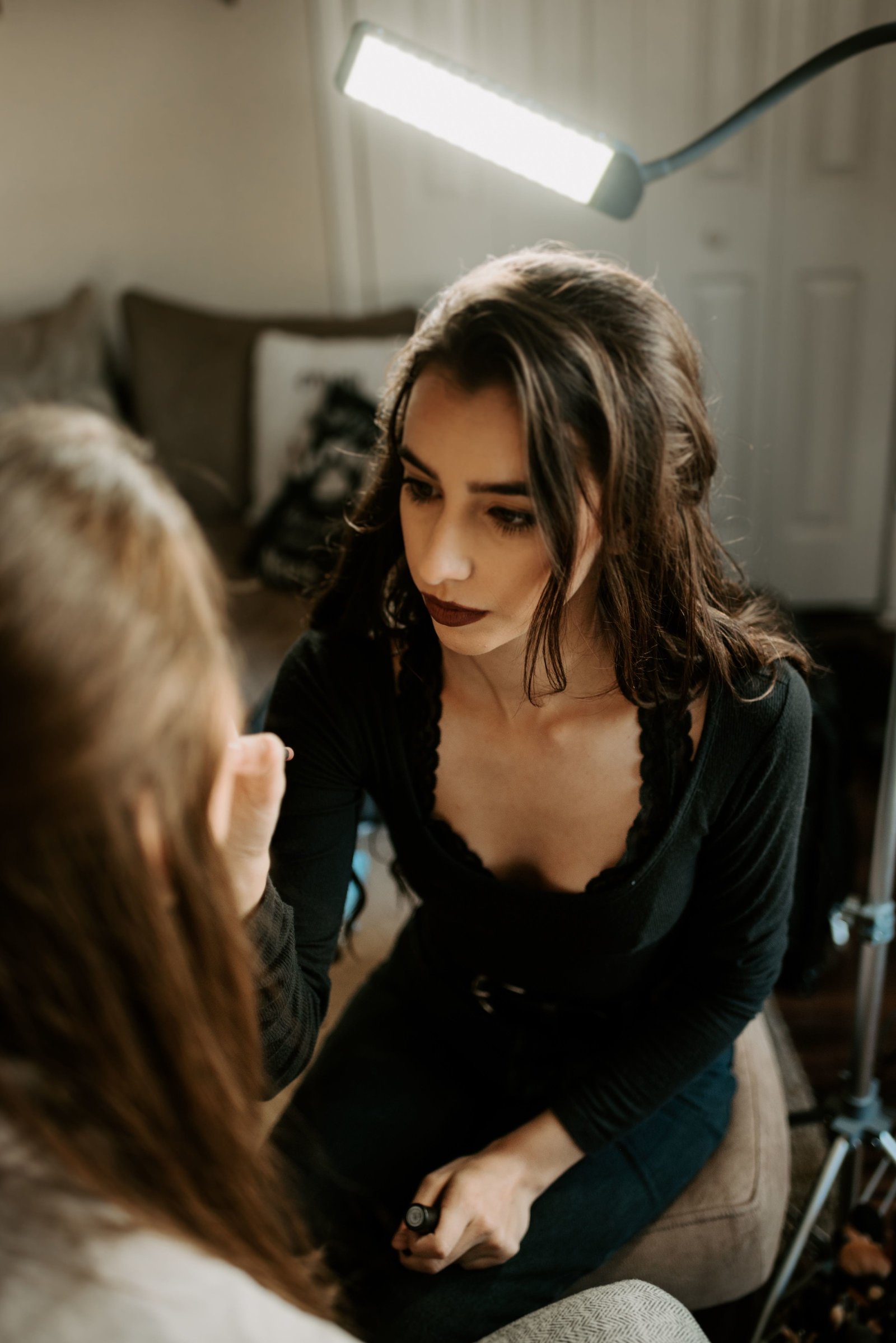 Katlyn sits applying makeup