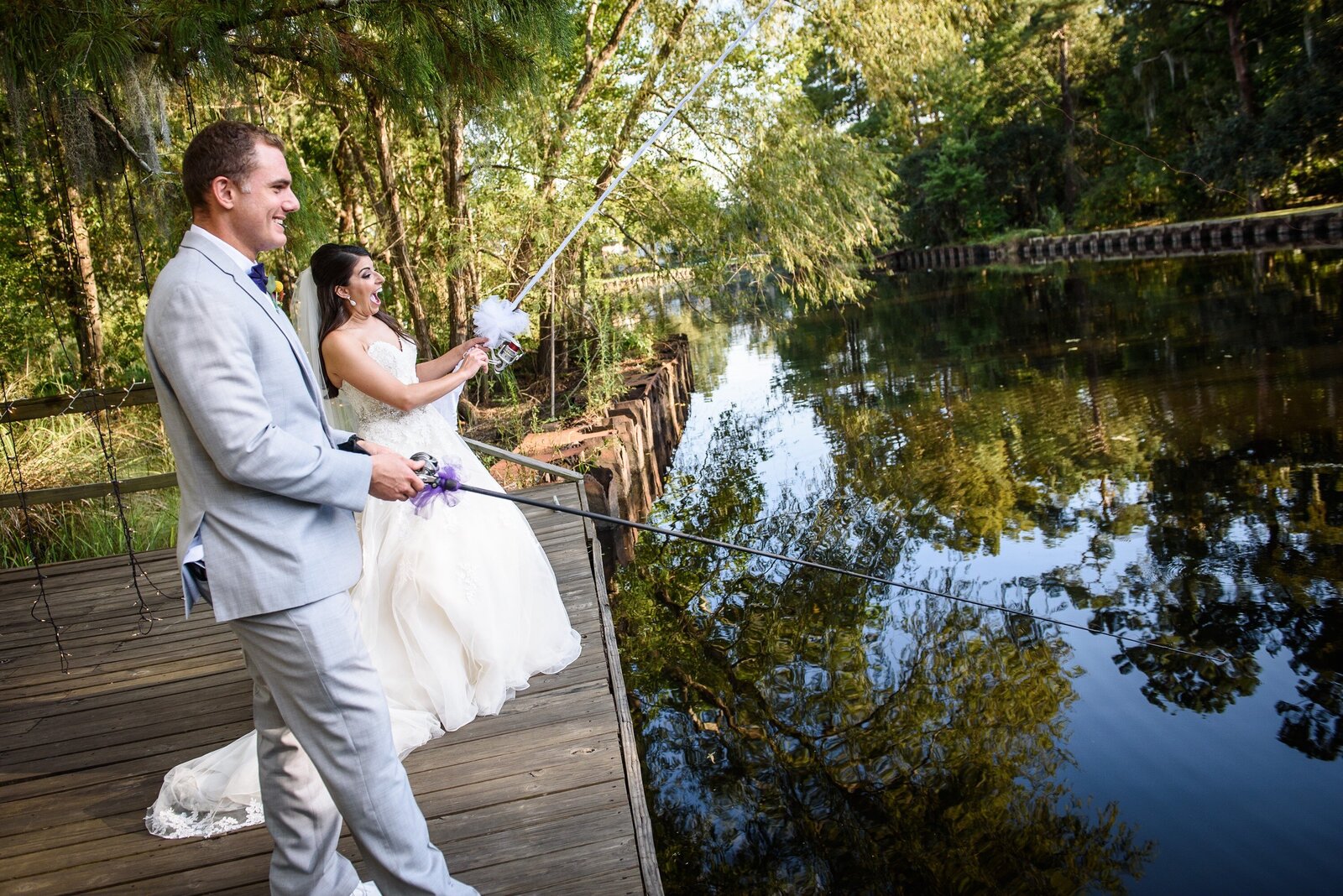 Bride and groom fishing from dock at Palmettos on the Bayou wedding in Slidell