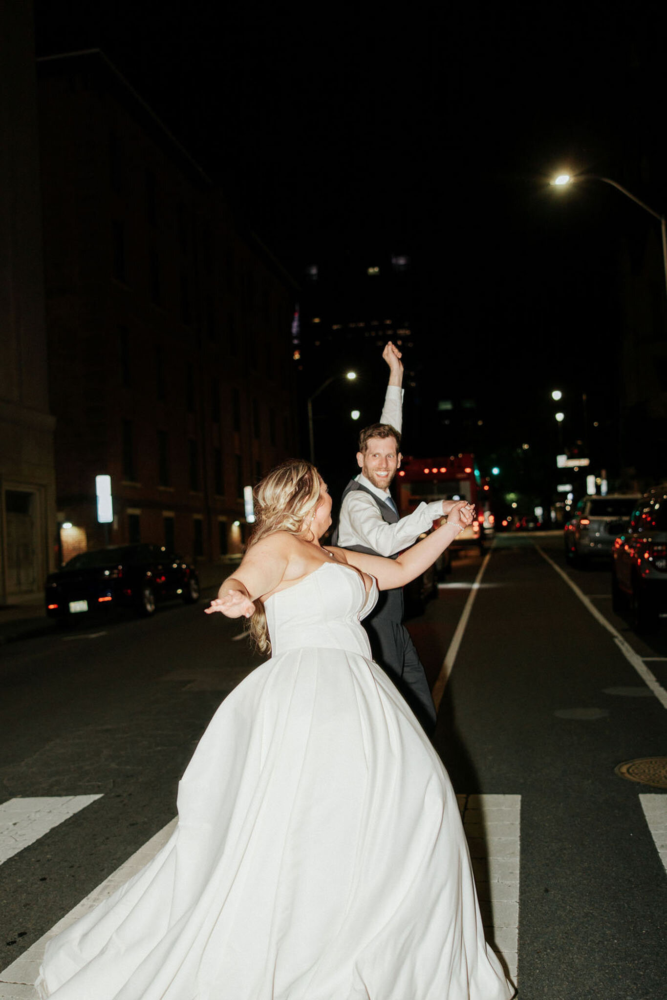 Bride and groom happily crossing the street
