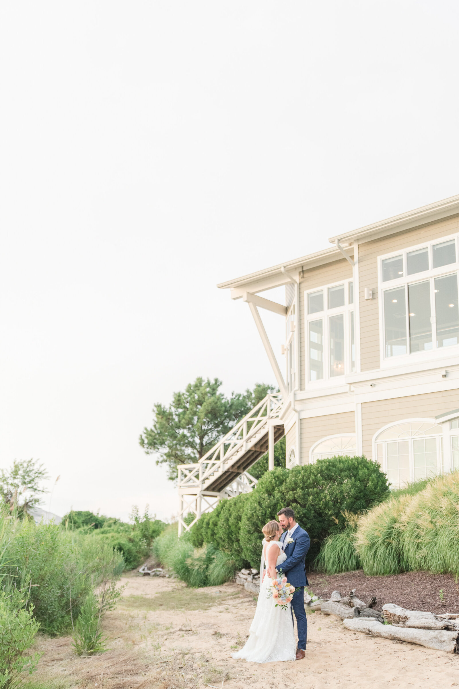 bride and groom on the beach kissing at sunset