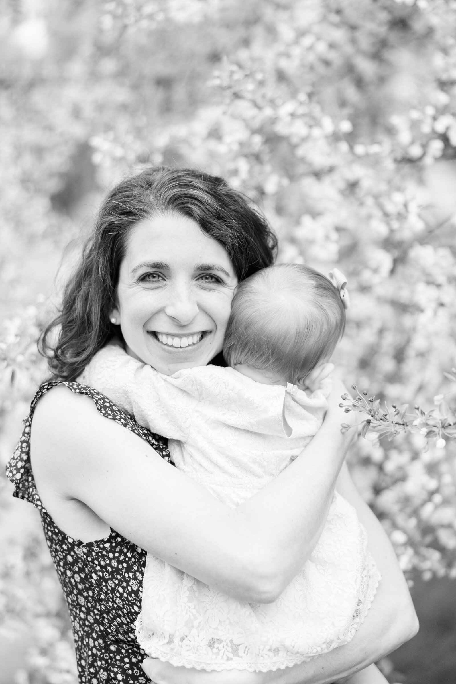 motherhood photography mother holding baby girl spring blossoms light and airy Akron Photographer