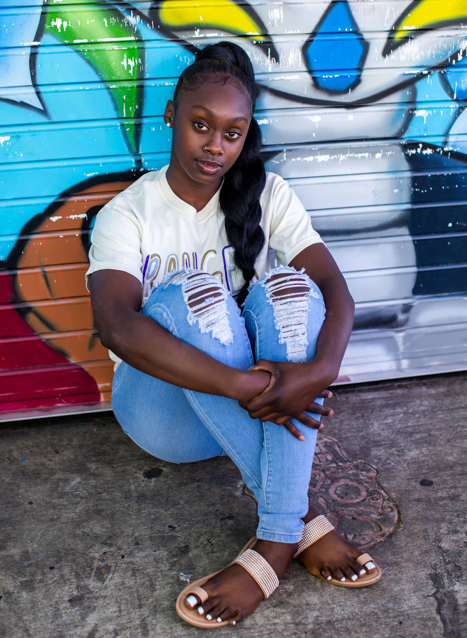 girl seated by mural
