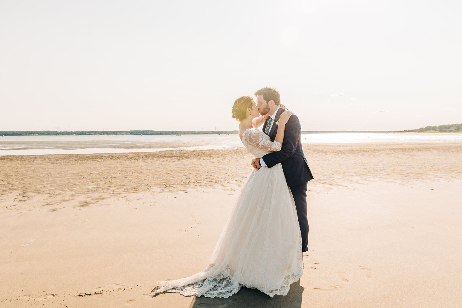 portrait of a bride and groom kissing on the beach