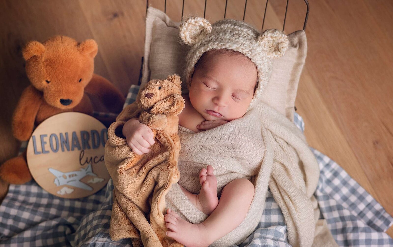 A sleeping newborn cuddles a teddy bear, captured in a cozy in-home session by Orlando newborn photographer Bia Schaefer.