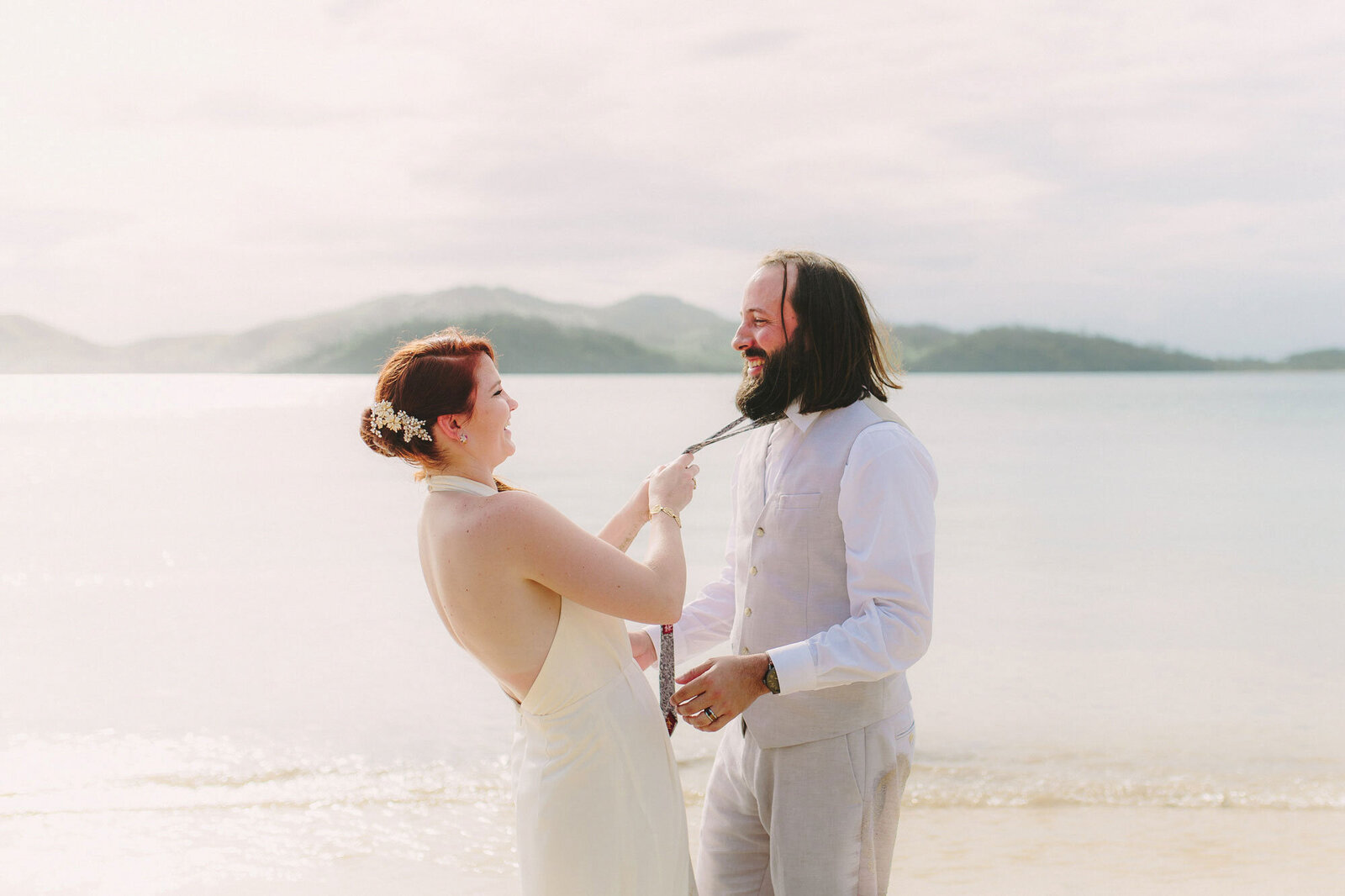 bride hanging on to groom's tie