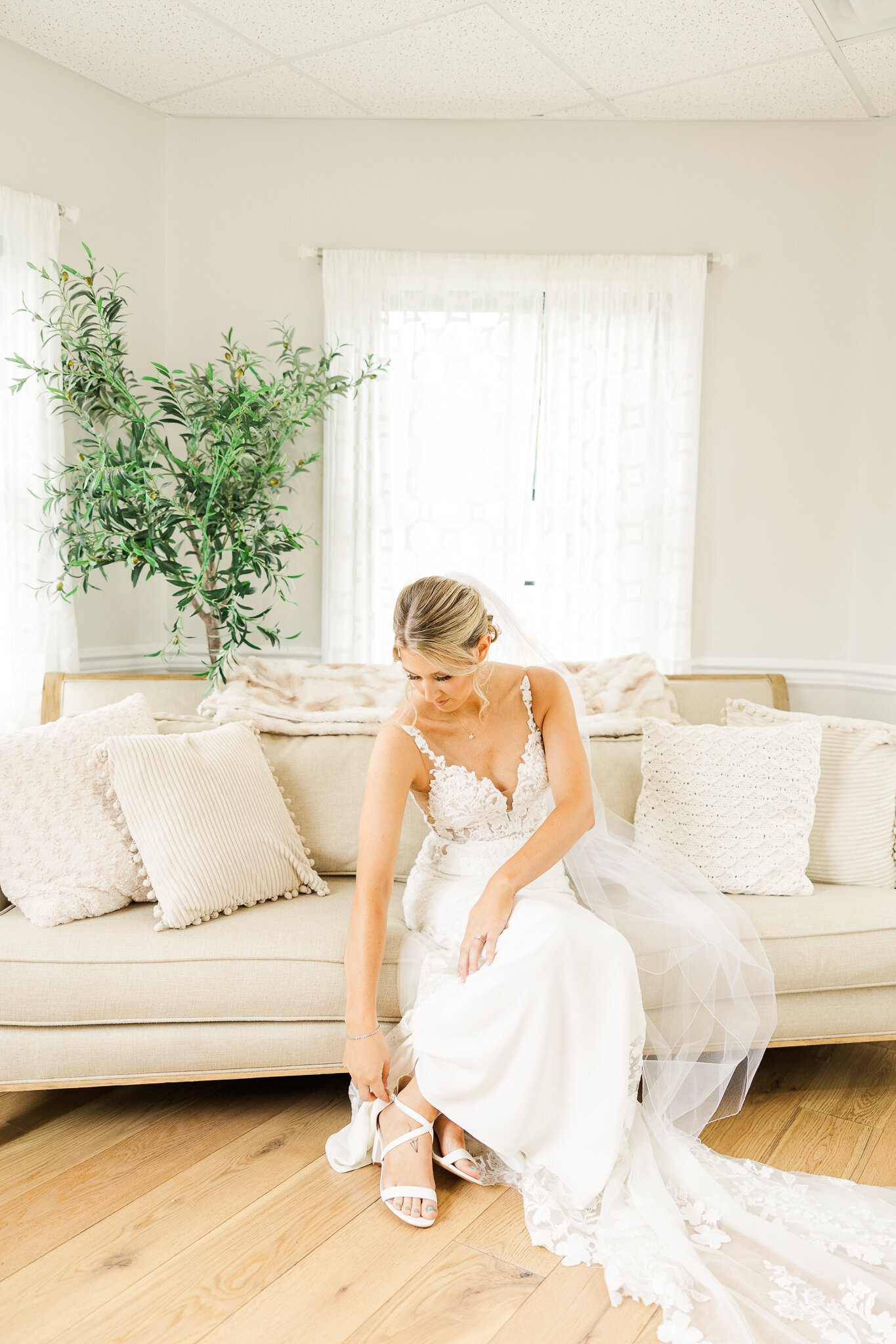  Bride bending down to fix her shoe before ceremony at SkyView Golf Club in Sparta, New Jersey