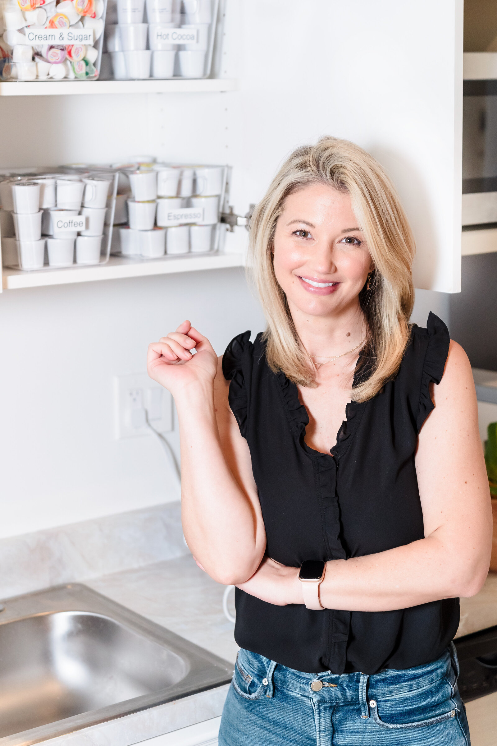 brand photo of a professional organizer posing in front of the kitchen cabinet