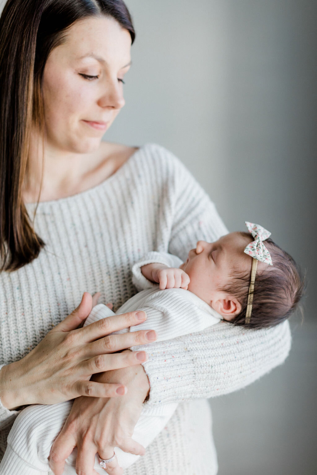 A mother holding her newborn daughter during a lifestyle newborn session in Richmond, Virginia