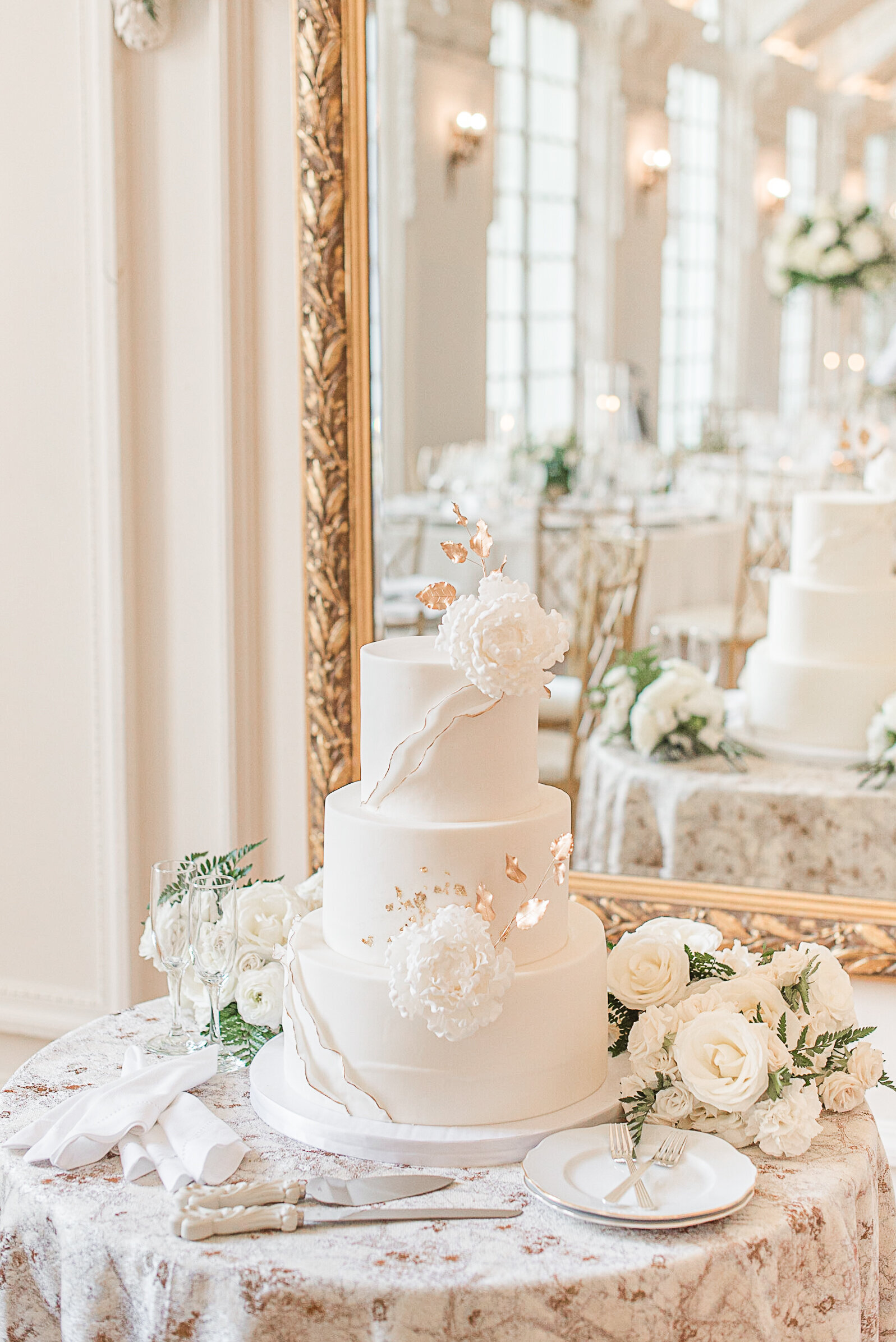 designer wedding cake white flowers with gold trim accents