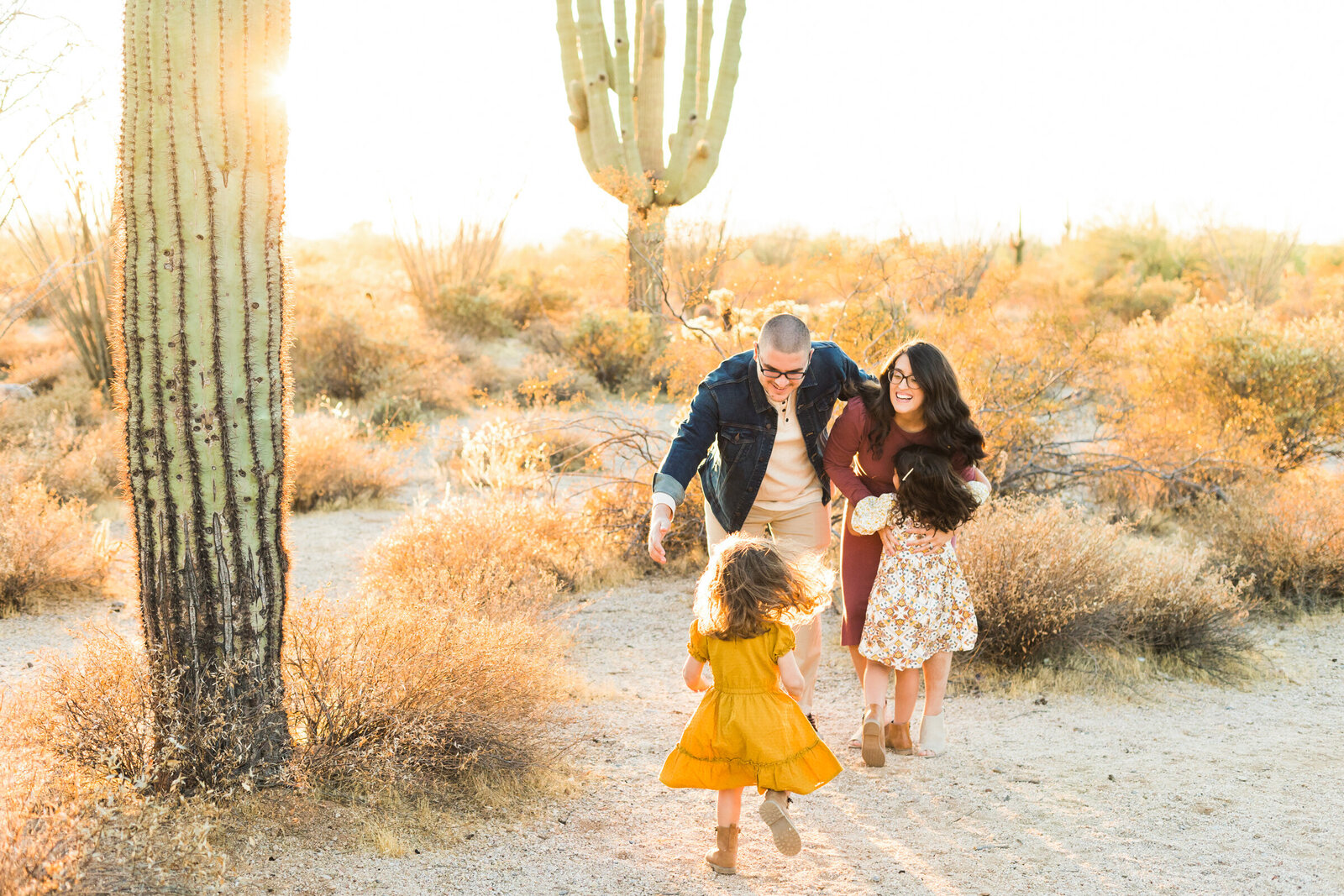 little girls running to mom and dad in Scottsdale Family Photography session